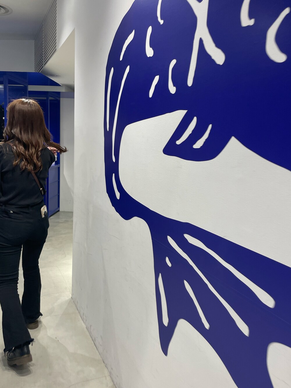 ブラック系のトップス、ブラック系のデニムパンツ、ブラウン系のショルダーバッグを着用したレディースの夏コーディネートの2枚目の写真