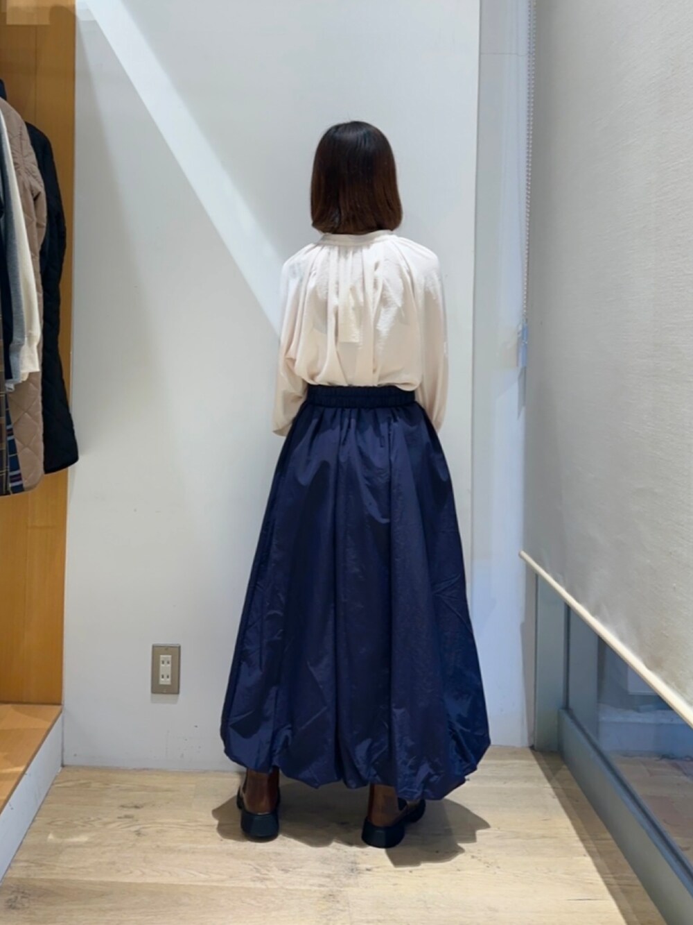 ホワイト系のシャツ/ブラウス、ブルー系のスカート、ブラウン系のハンドバッグを着用したレディースの冬コーディネートの3枚目の写真