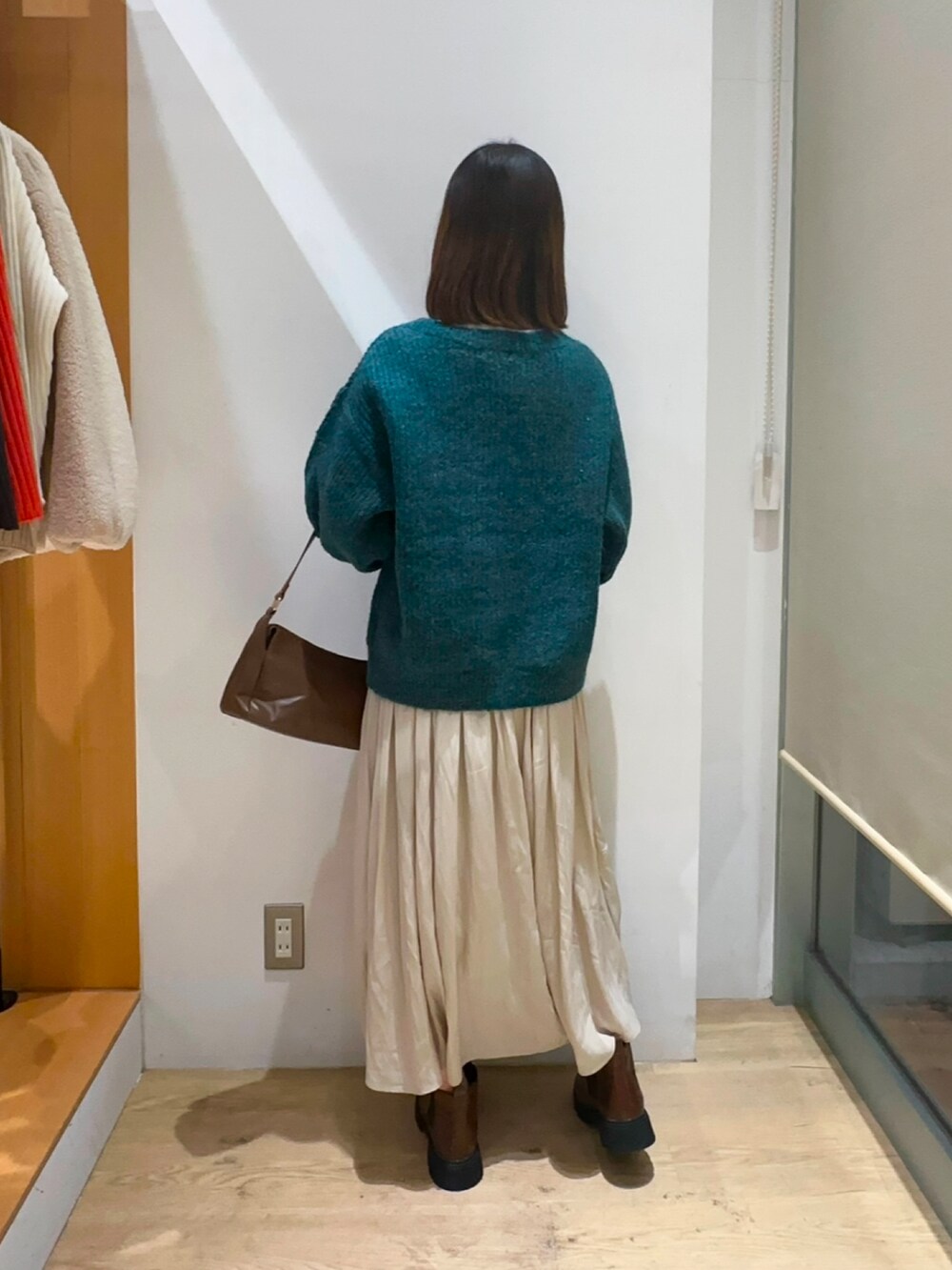 グリーン系のニット/セーター、ホワイト系のニット/セーター、ベージュ系のスカートを着用したレディースの冬コーディネートの2枚目の写真