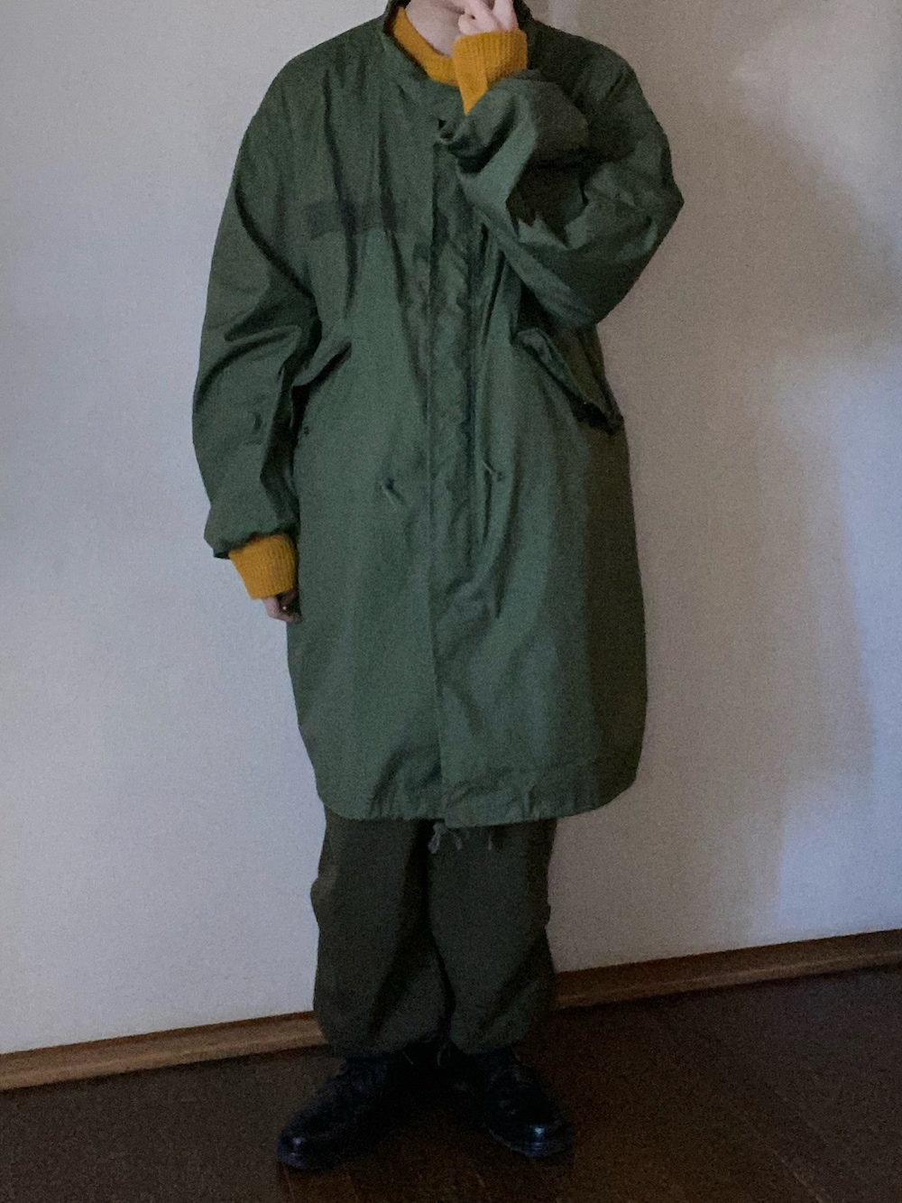 イエロー系のニット/セーター、グリーン系のその他パンツ、シルバー系のリングを着用したメンズの冬コーディネートの2枚目の写真