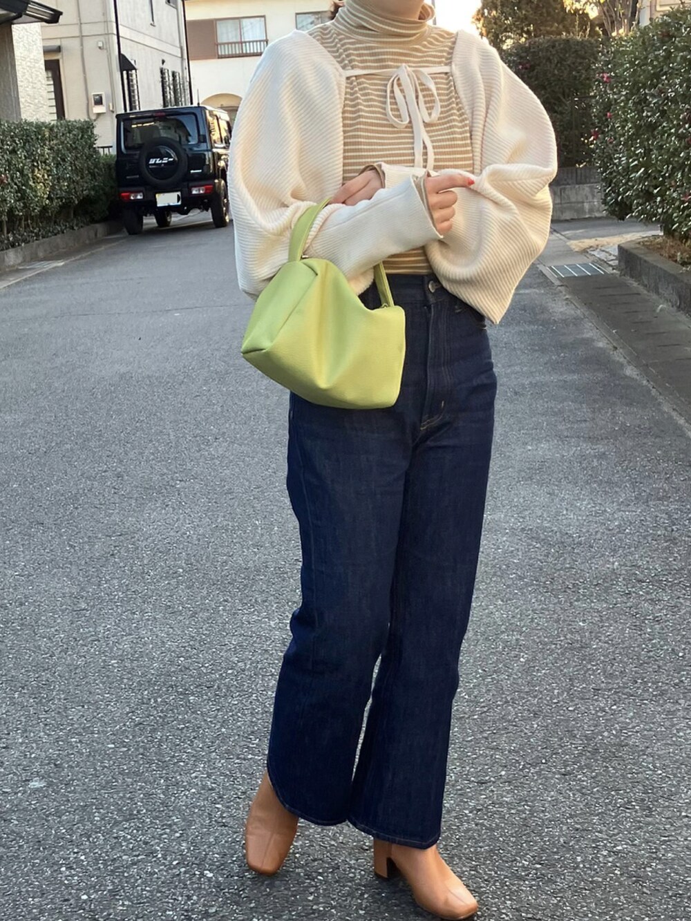 ベージュ系のTシャツ/カットソー、ホワイト系のカーディガン/ボレロ、ブルー系のデニムパンツを着用したレディースの冬コーディネートの2枚目の写真