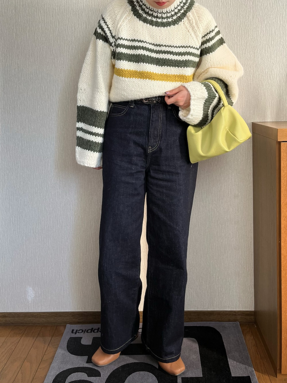 ホワイト系のニット/セーター、ホワイト系のブルゾン、イエロー系のショルダーバッグを着用したレディースの冬コーディネートの2枚目の写真