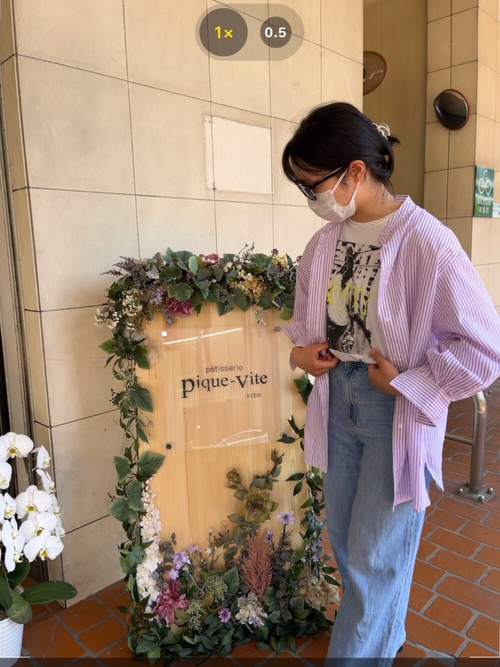 ピンク系のシャツ/ブラウス、ブルー系のデニムパンツ、ブラック系のサングラスを着用したレディースの春コーディネートの2枚目の写真