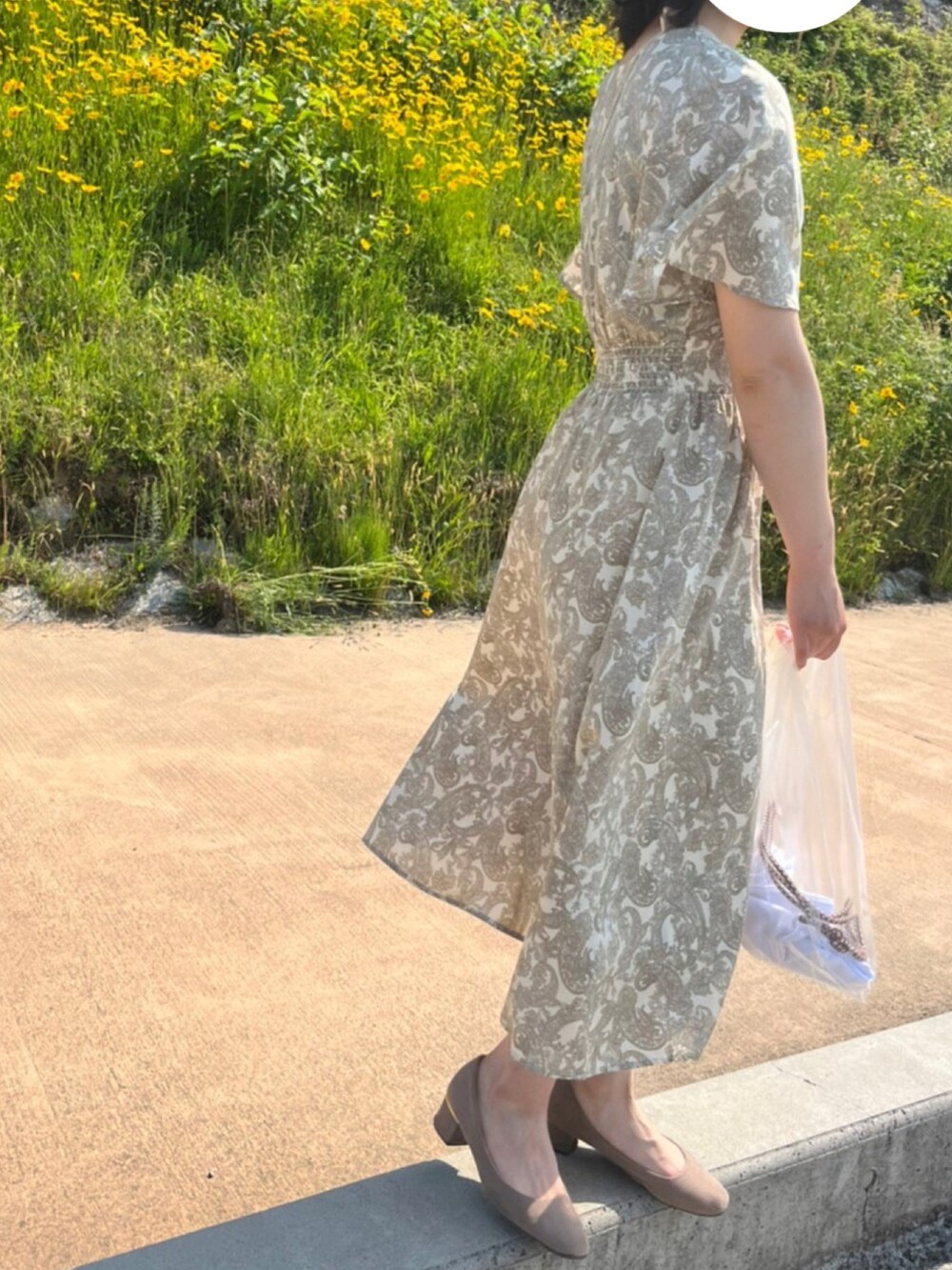 ピンク系のパンプス、ベージュ系のショルダーバッグ、ベージュ系のワンピースを着用したレディースの春コーディネートの2枚目の写真