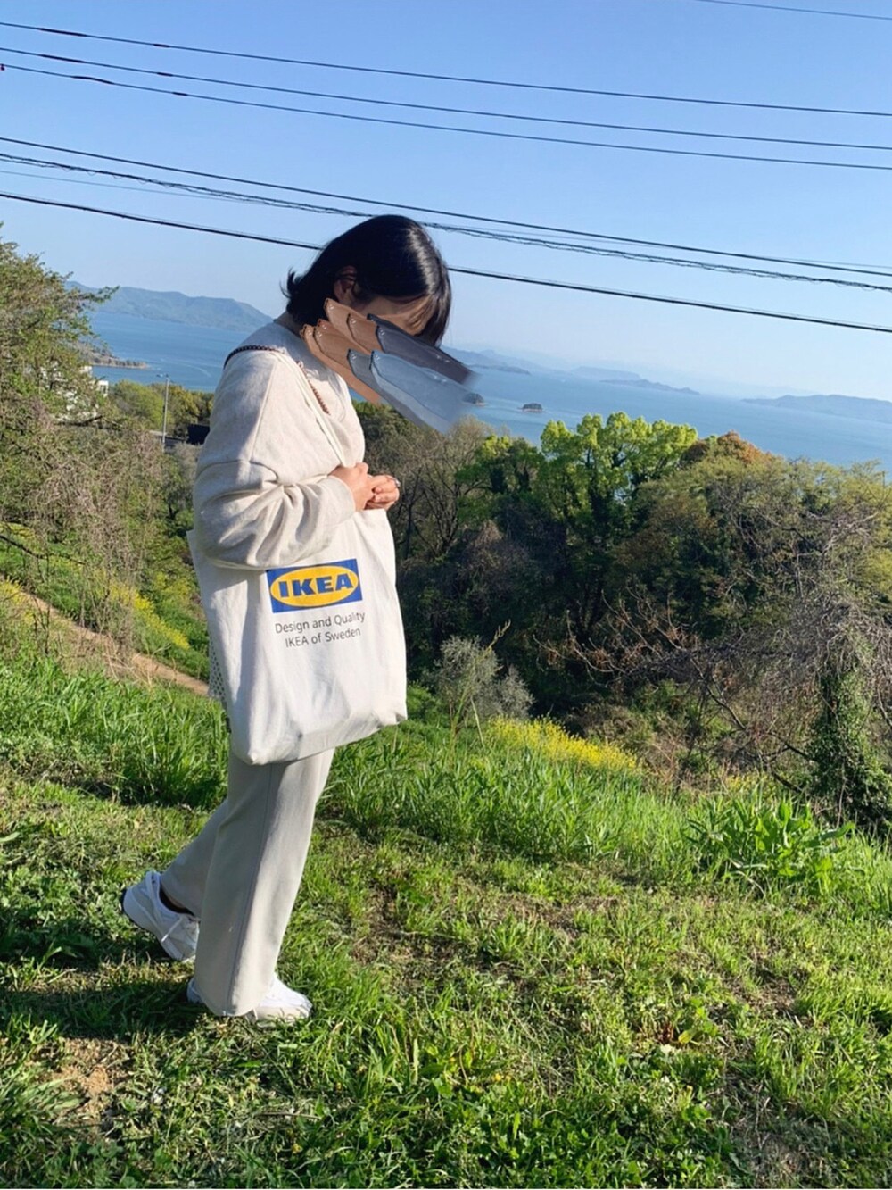 ホワイト系のパンツ、ホワイト系のトップス、ホワイト系のスニーカーを着用したレディースの春コーディネートの2枚目の写真