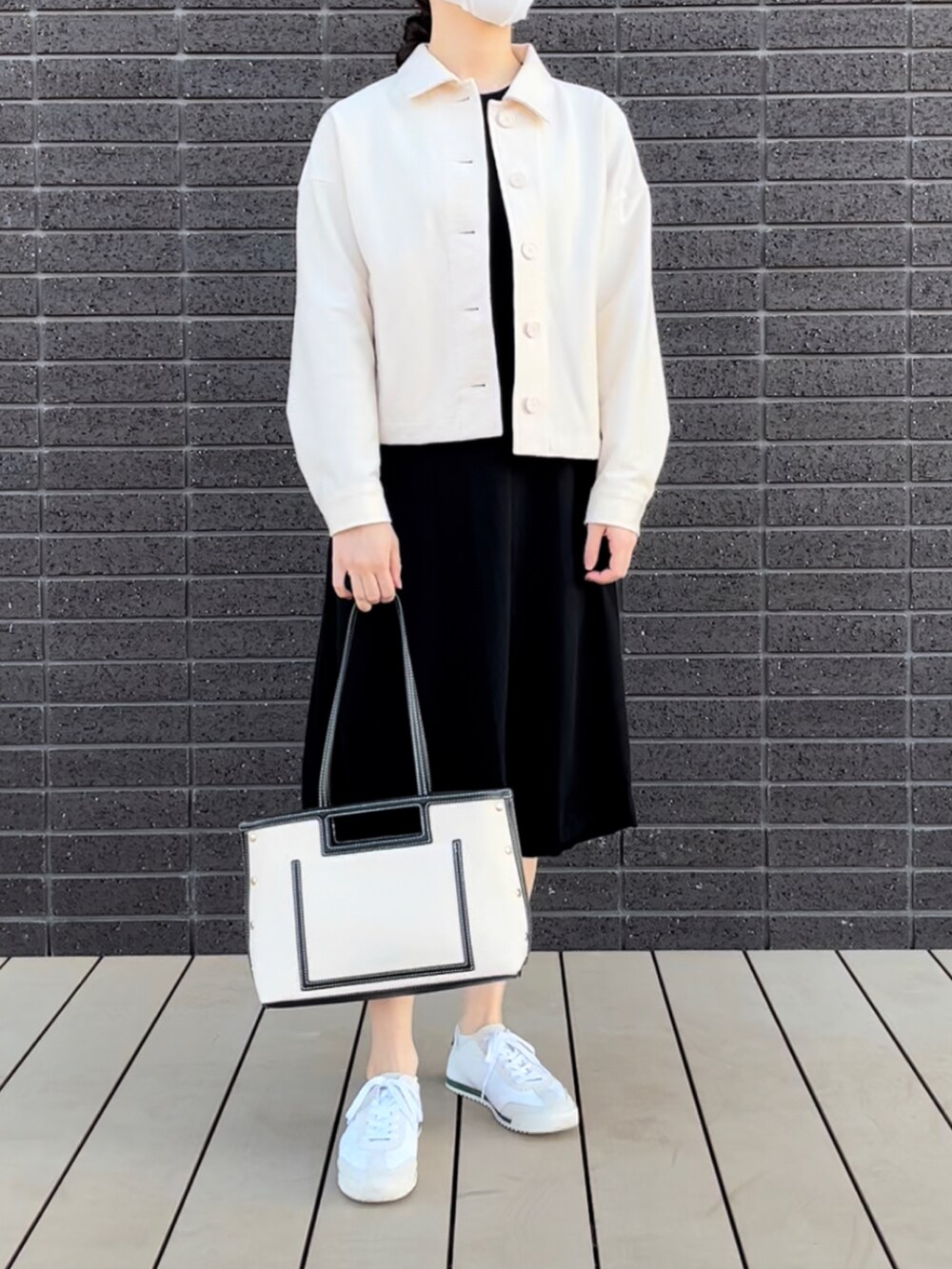 ホワイト系のジャケット/アウター、ホワイト系のバッグ、ブラック系のワンピースを着用したレディースの冬コーディネートの4枚目の写真