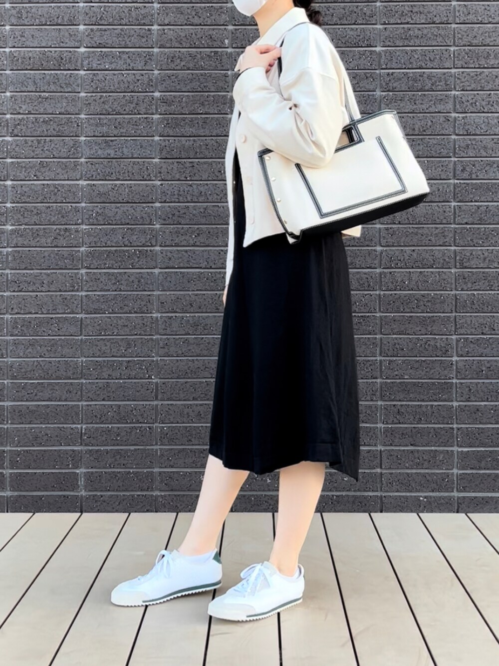 ホワイト系のジャケット/アウター、ホワイト系のバッグ、ブラック系のワンピースを着用したレディースの冬コーディネートの3枚目の写真