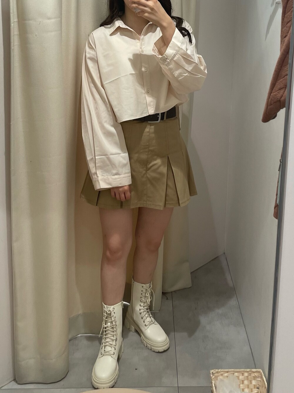 ベージュ系のスカート、ブラウン系のアンサンブル、ホワイト系のブーツを着用したレディースの秋コーディネートの2枚目の写真