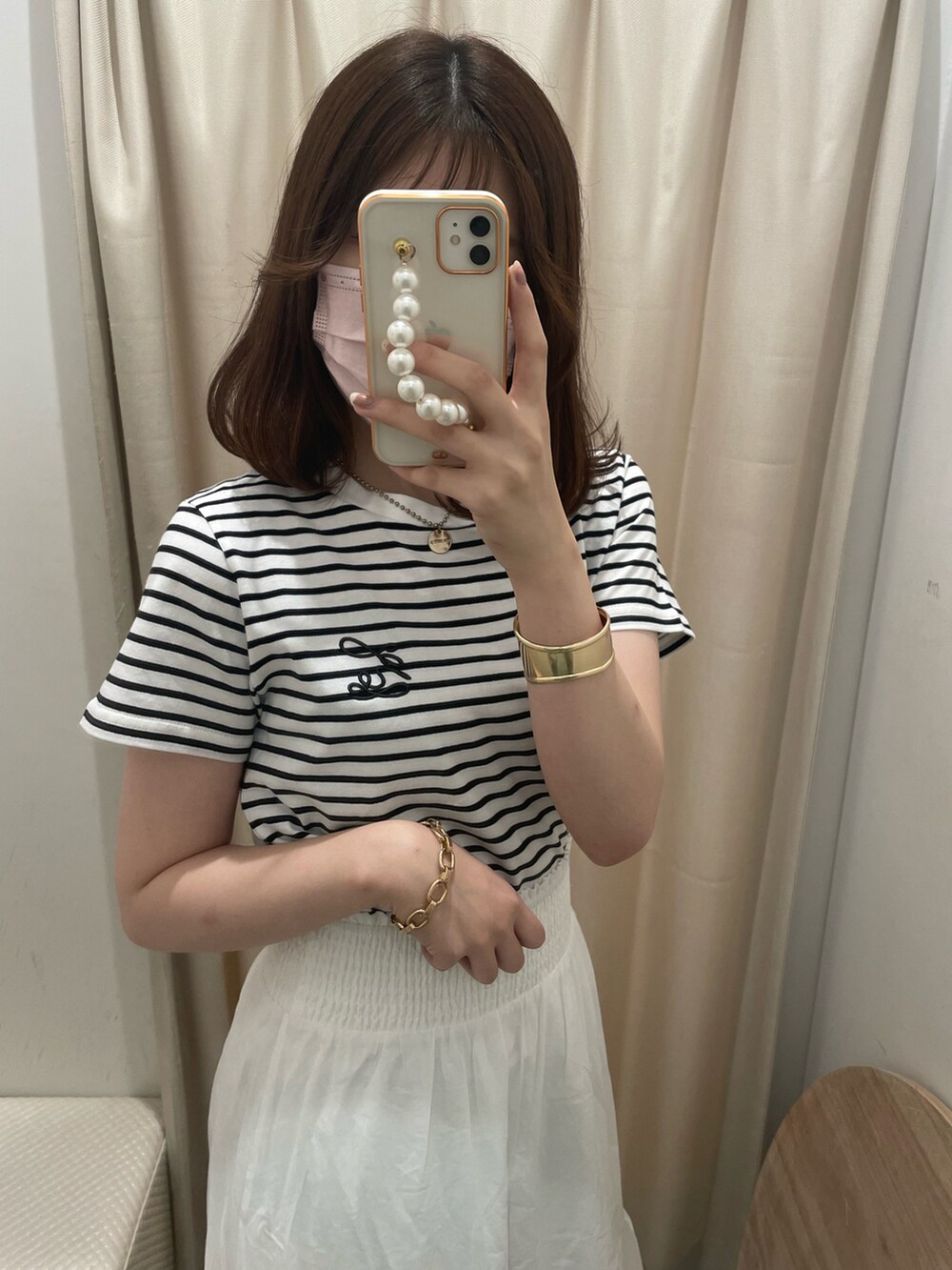 ホワイト系のTシャツ/カットソー、ホワイト系のスカート、ホワイト系のサンダルを着用したレディースの夏コーディネートの3枚目の写真