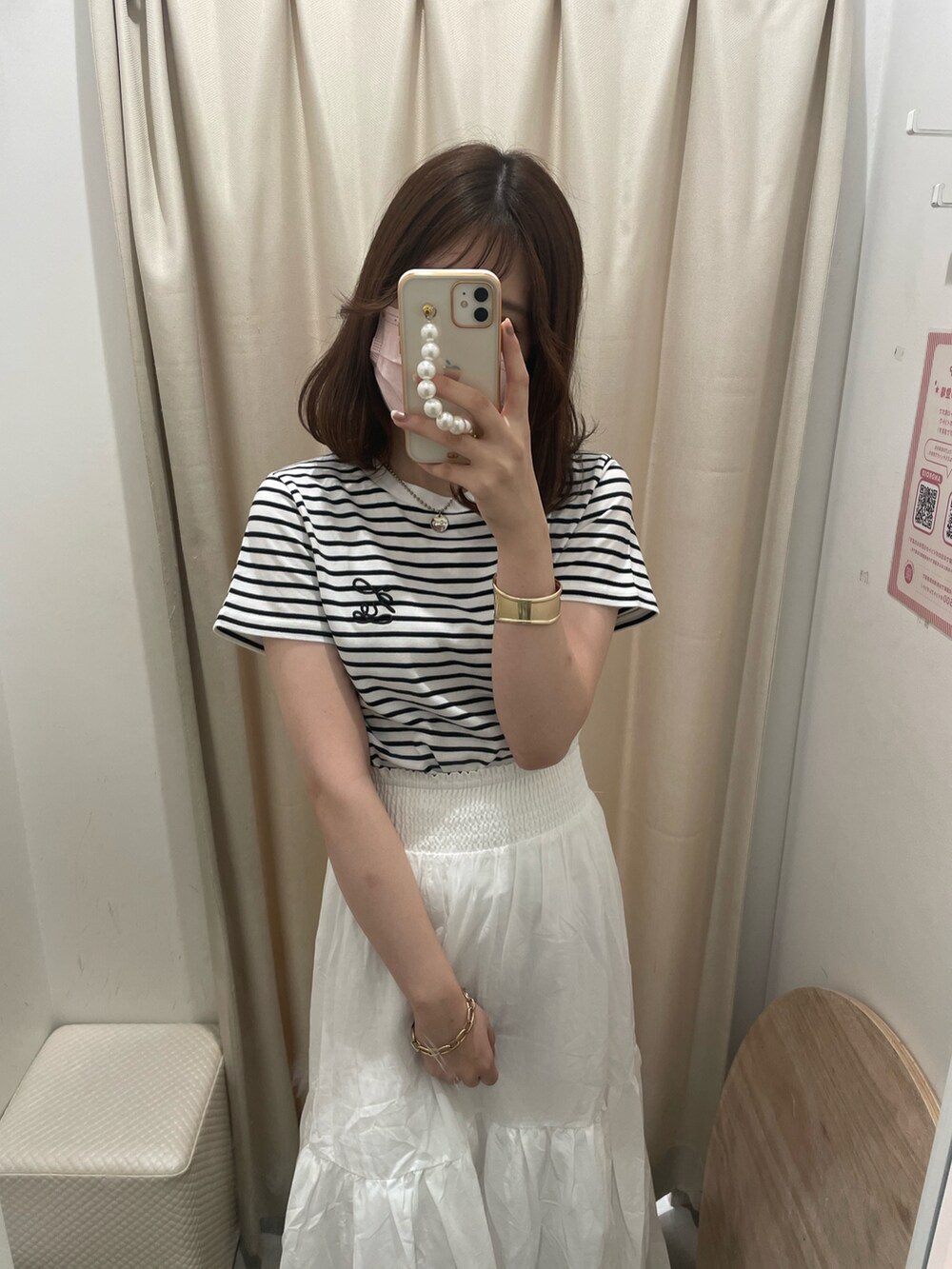 ホワイト系のTシャツ/カットソー、ホワイト系のスカート、ホワイト系のサンダルを着用したレディースの夏コーディネートの2枚目の写真