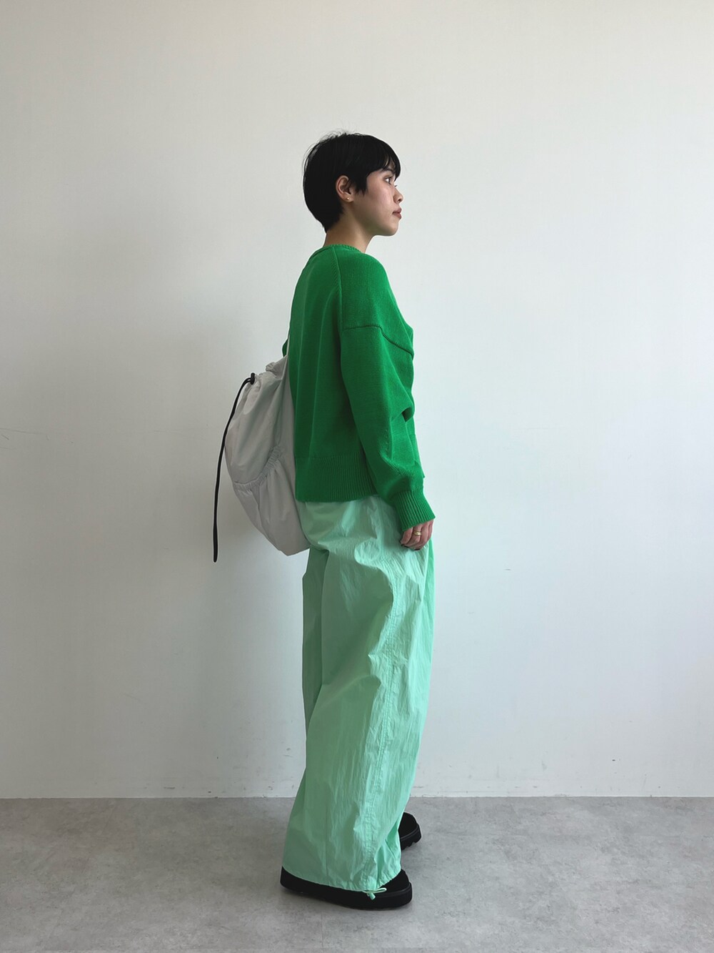 グリーン系のカーディガン/ボレロ、グリーン系のその他パンツ、ブラック系のブーツを着用したレディースの冬コーディネートの3枚目の写真