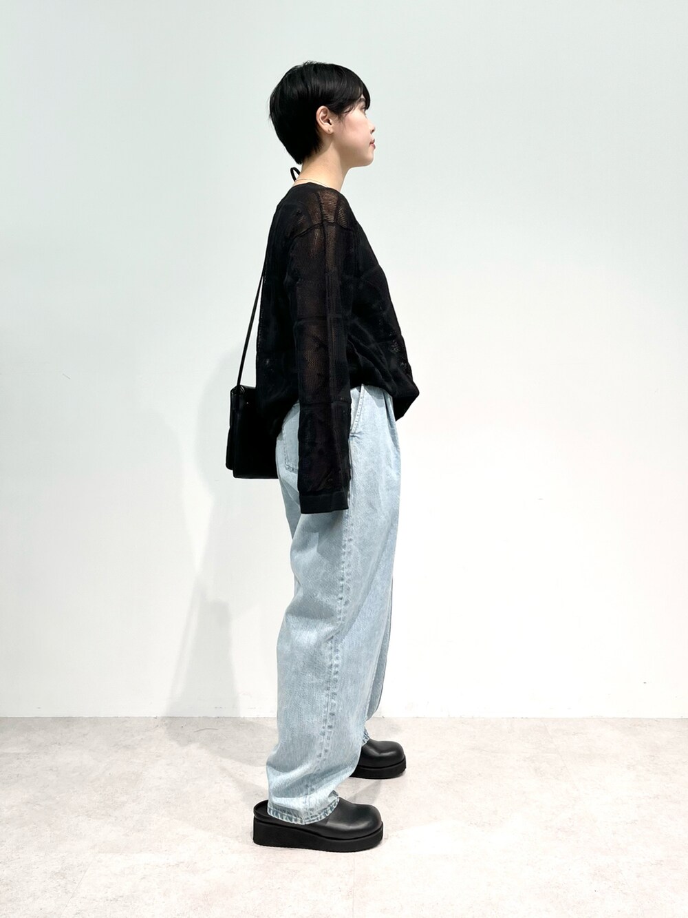 ブラック系のニット/セーター、ブルー系のデニムパンツ、ブラック系のその他シューズを着用したレディースの夏コーディネートの2枚目の写真