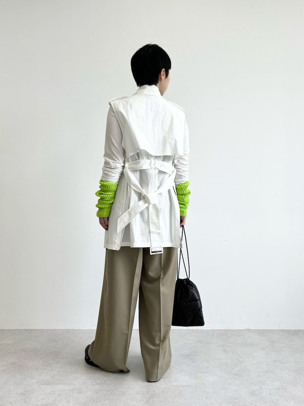 ホワイト系のベスト、ブラック系のベスト、ブラック系のハンドバッグを着用したレディースの冬コーディネートの2枚目の写真