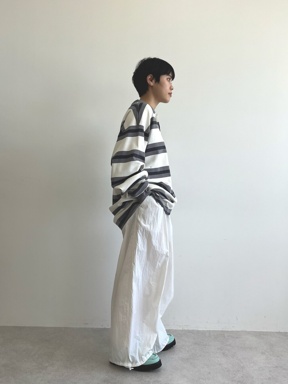 ブラック系のポロシャツ、ホワイト系のその他パンツ、ブルー系のブーツを着用したレディースの冬コーディネートの3枚目の写真