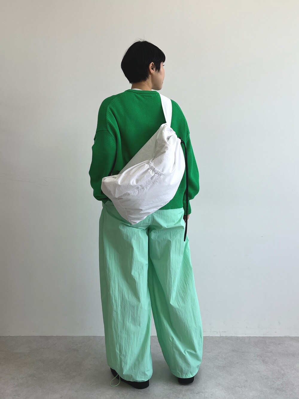 グリーン系のカーディガン/ボレロ、グリーン系のその他パンツ、ブラック系のブーツを着用したレディースの冬コーディネートの4枚目の写真