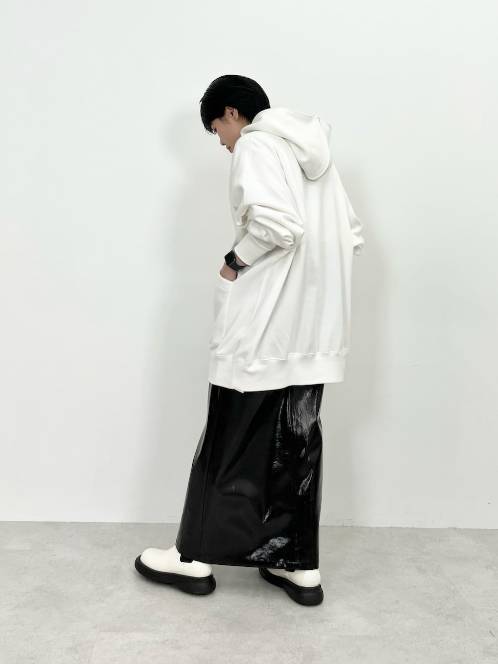 ホワイト系のパーカー、ブラック系のスカート、ホワイト系のブーツを着用したレディースの秋コーディネートの4枚目の写真
