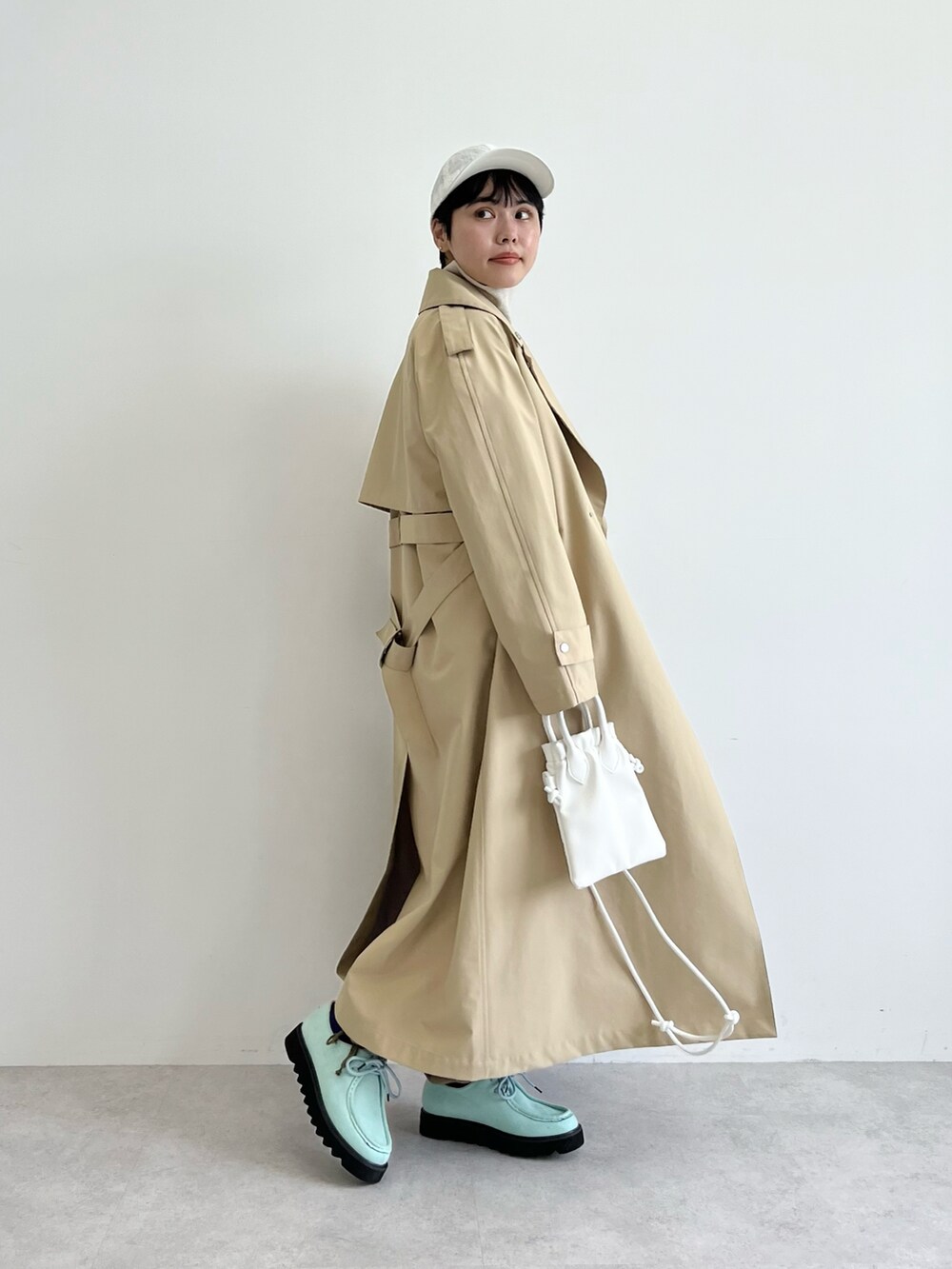 グレー系のスウェット、グリーン系のカーゴパンツ、ホワイト系のショルダーバッグを着用したレディースの冬コーディネートの2枚目の写真