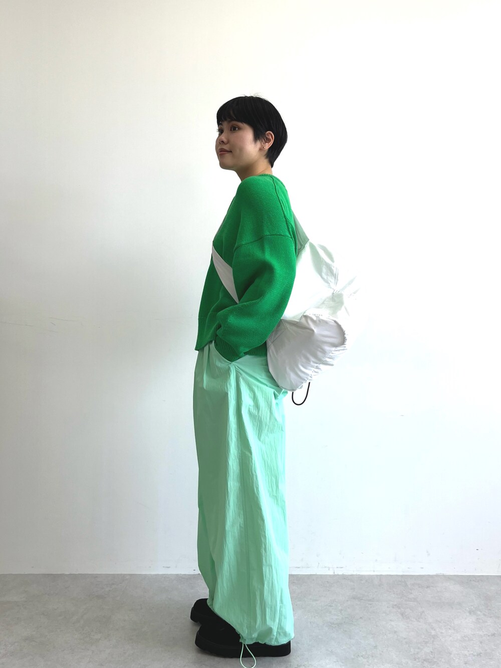 グリーン系のカーディガン/ボレロ、グリーン系のその他パンツ、ブラック系のブーツを着用したレディースの冬コーディネートの2枚目の写真