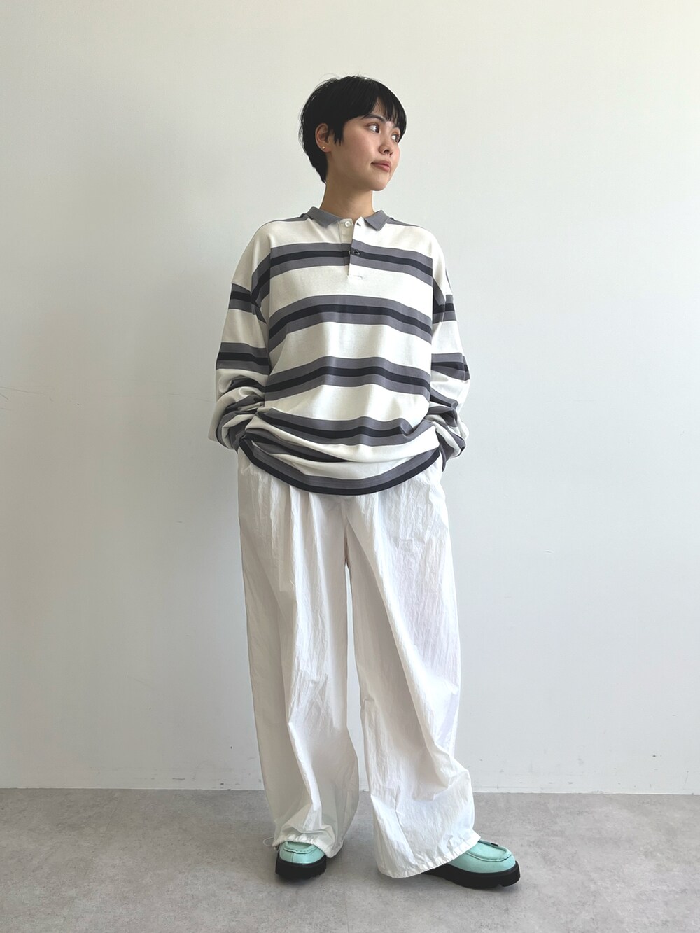 ブラック系のポロシャツ、ホワイト系のその他パンツ、ブルー系のブーツを着用したレディースの冬コーディネートの2枚目の写真