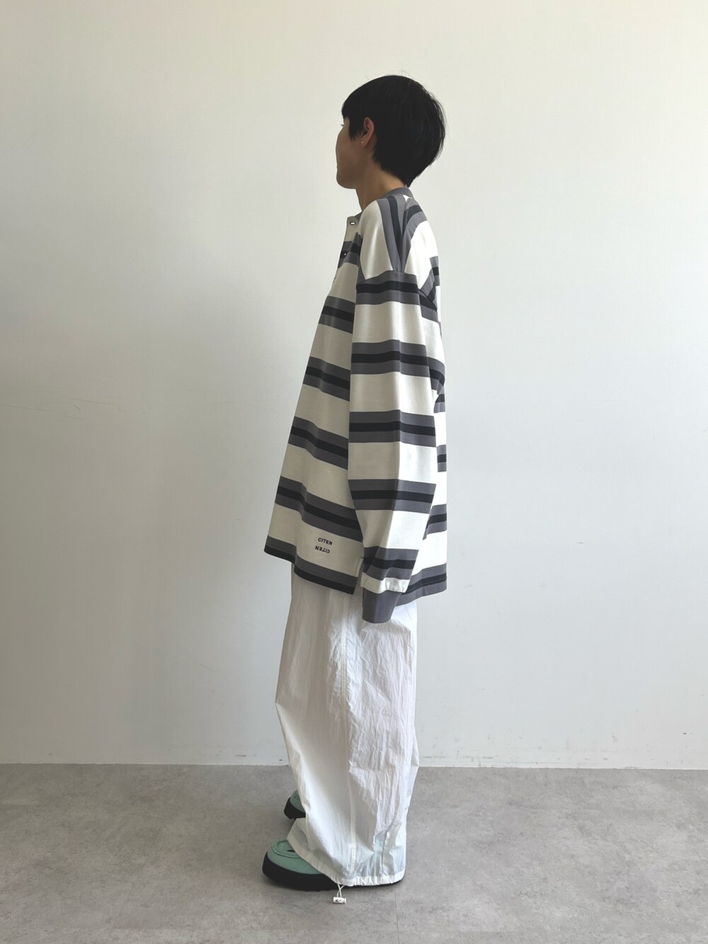 ブラック系のポロシャツ、ホワイト系のその他パンツ、ブルー系のブーツを着用したレディースの冬コーディネートの4枚目の写真