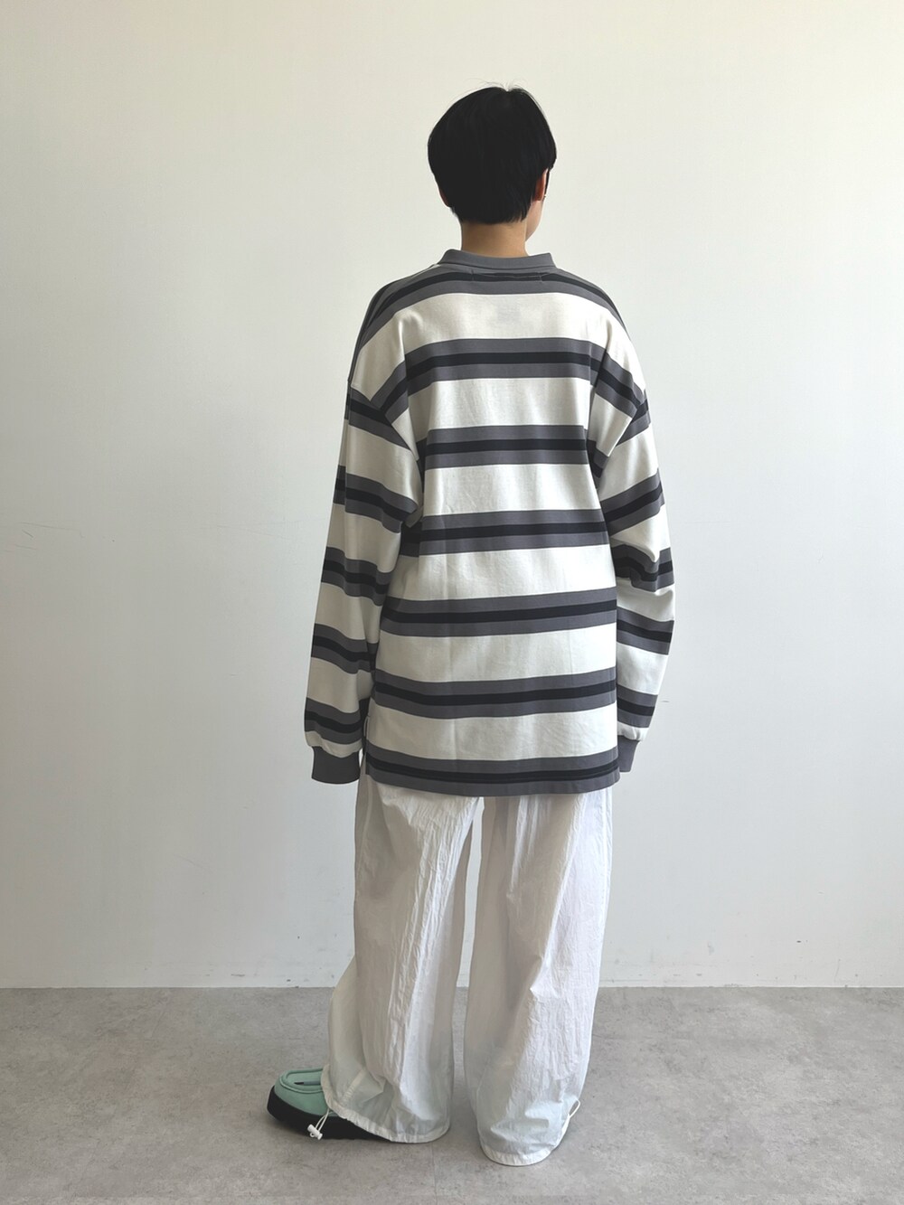 ブラック系のポロシャツ、ホワイト系のその他パンツ、ブルー系のブーツを着用したレディースの冬コーディネートの5枚目の写真