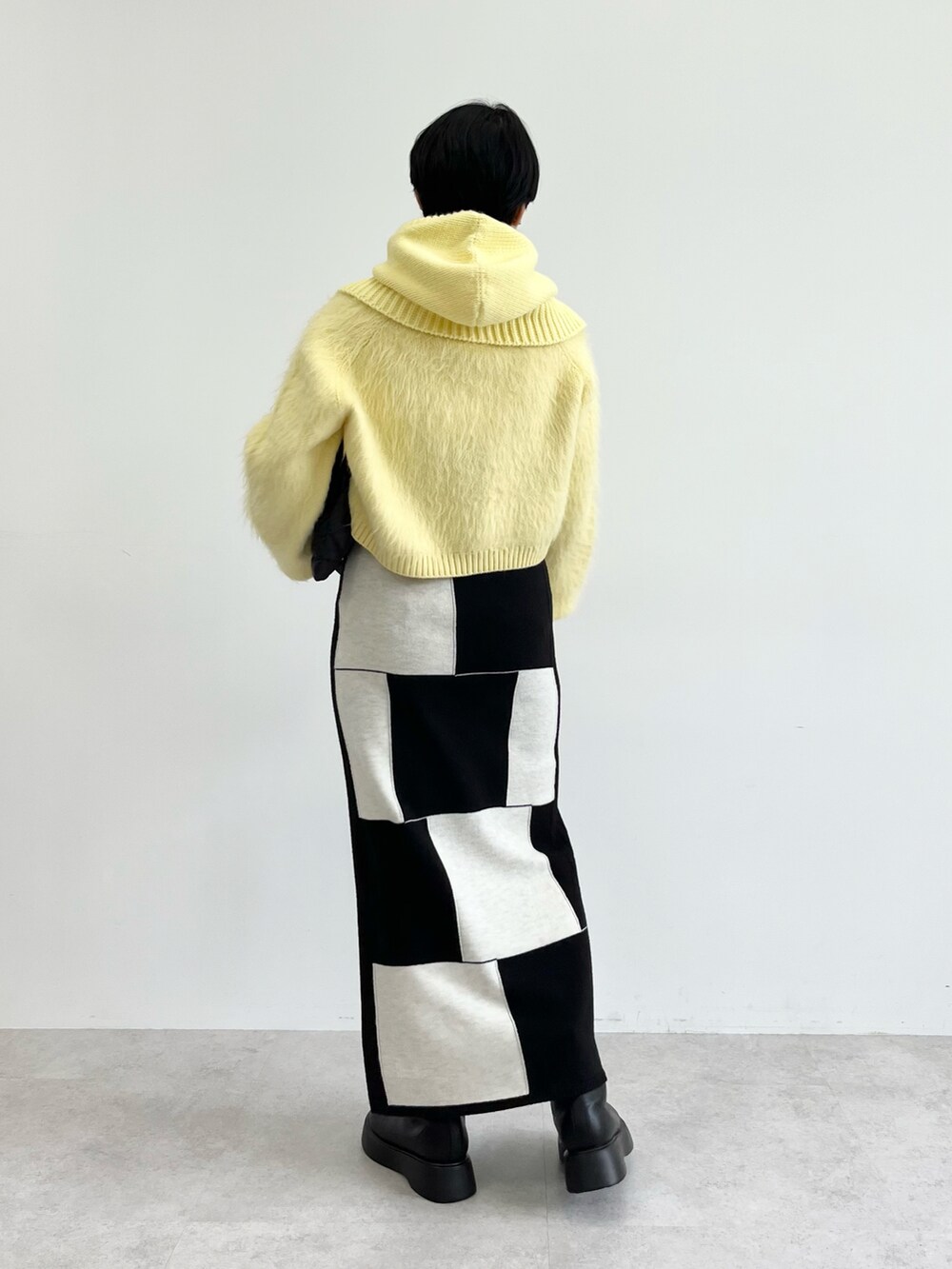 ベージュ系のニット/セーター、ブラック系のスカート、ブラック系のトートバッグを着用したレディースの秋コーディネートの3枚目の写真