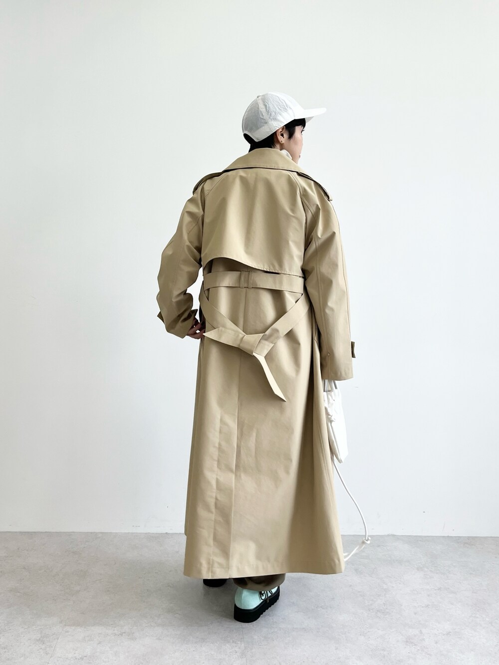 グレー系のスウェット、グリーン系のカーゴパンツ、ホワイト系のショルダーバッグを着用したレディースの冬コーディネートの3枚目の写真