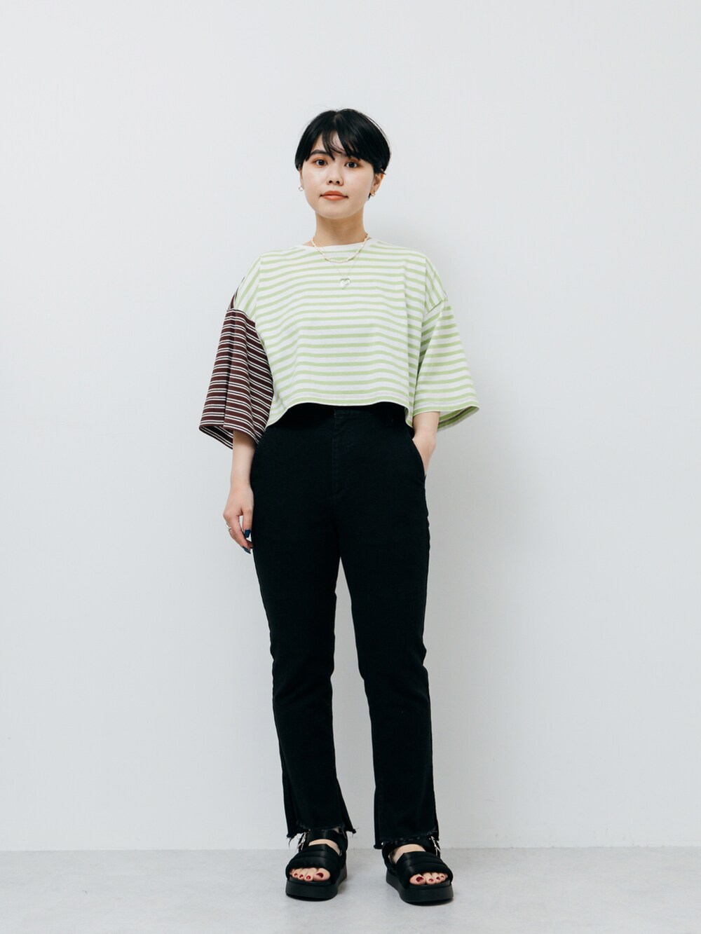 グリーン系のTシャツ/カットソー、ブラック系のサンダル、ブラック系のデニムパンツを着用したレディースの夏コーディネートの2枚目の写真