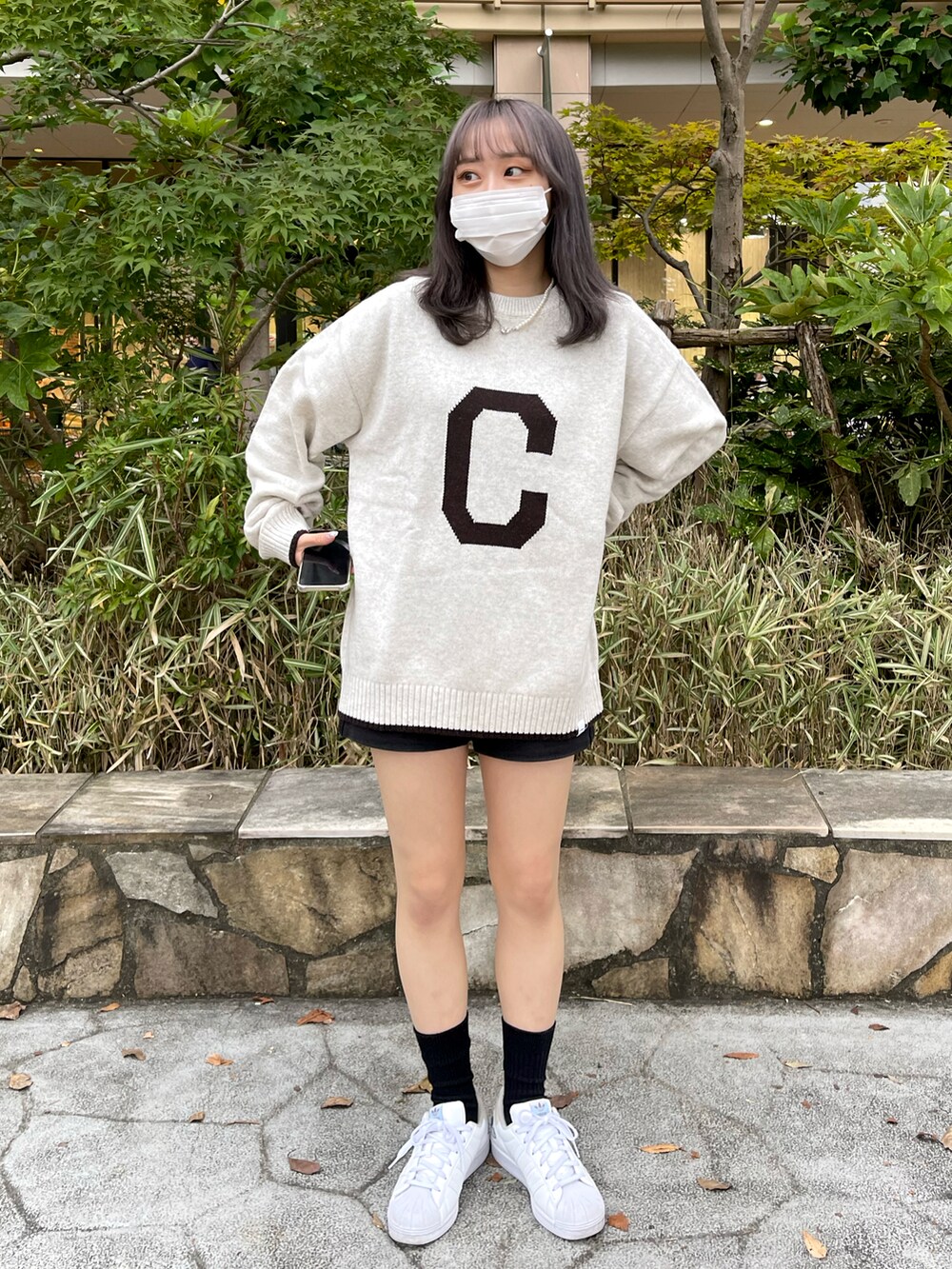 ベージュ系のニット/セーター、ホワイト系のスニーカーを着用したレディースの秋コーディネートの2枚目の写真