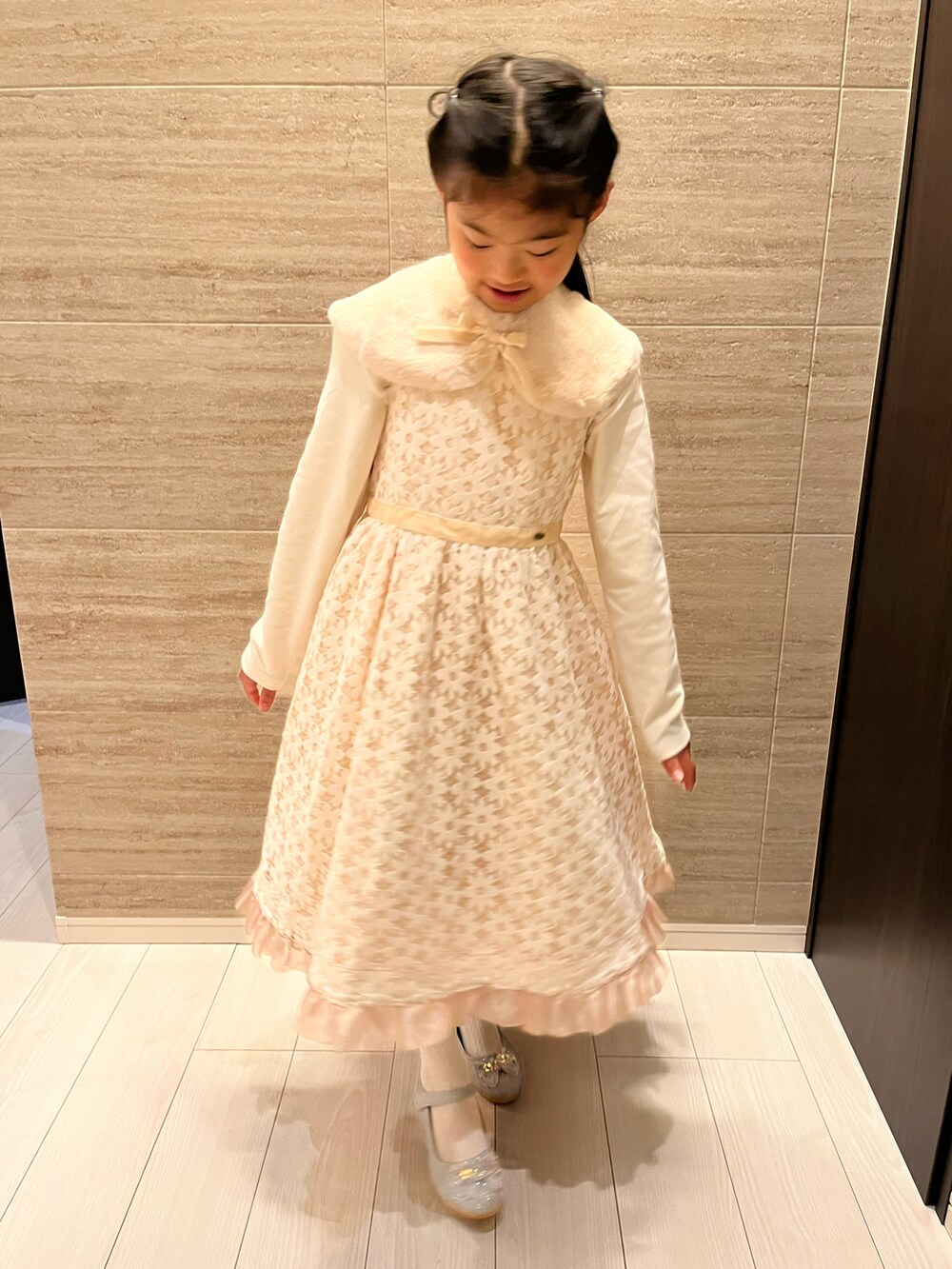 ホワイト系のドレス、シルバー系のパンプス、ホワイト系のTシャツ/カットソーを着用したキッズの冬コーディネートの4枚目の写真