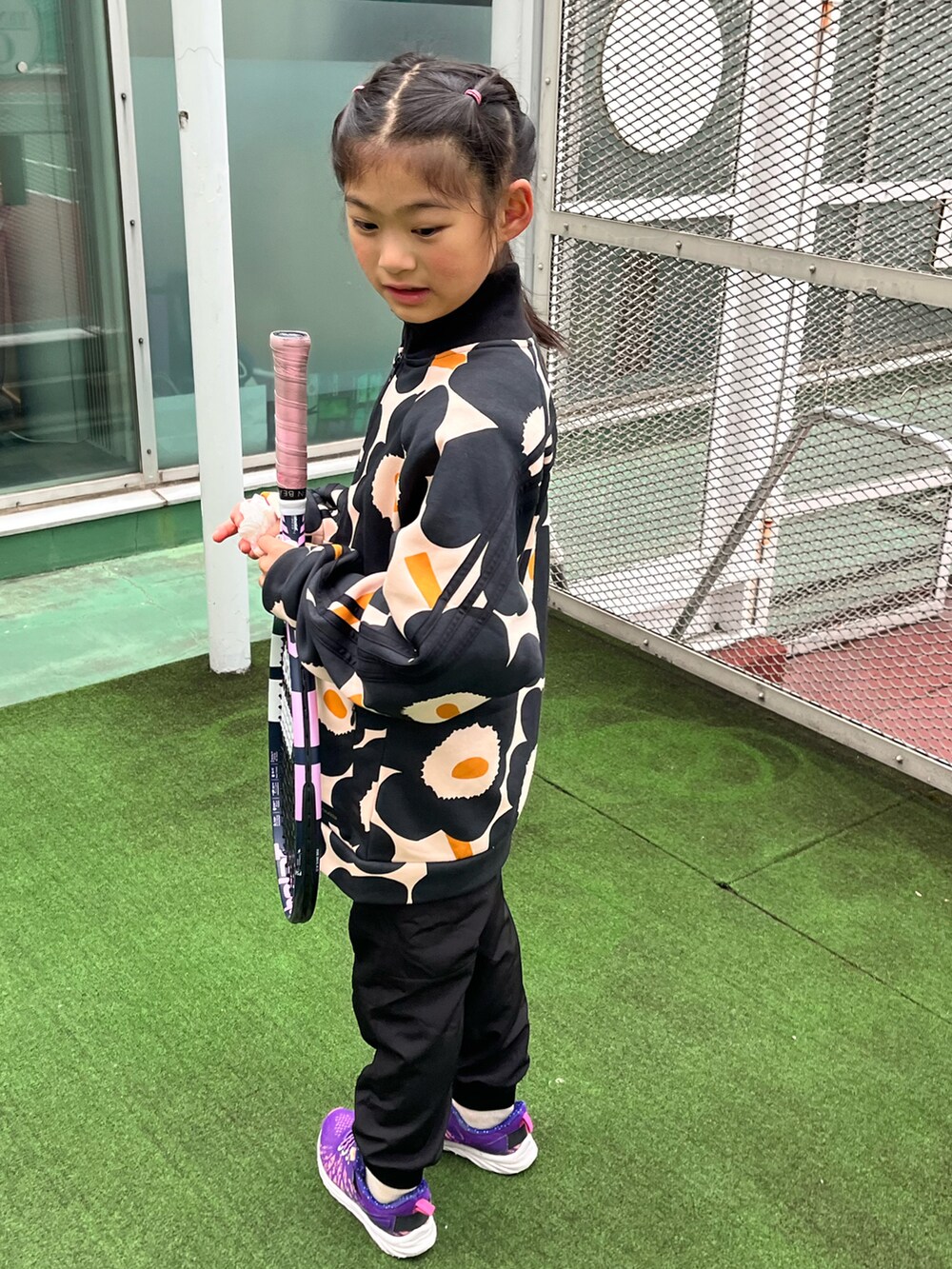 ブラック系のパンツ、パープル系のスニーカー、ブラック系のスポーツグッズを着用したキッズの冬コーディネートの2枚目の写真