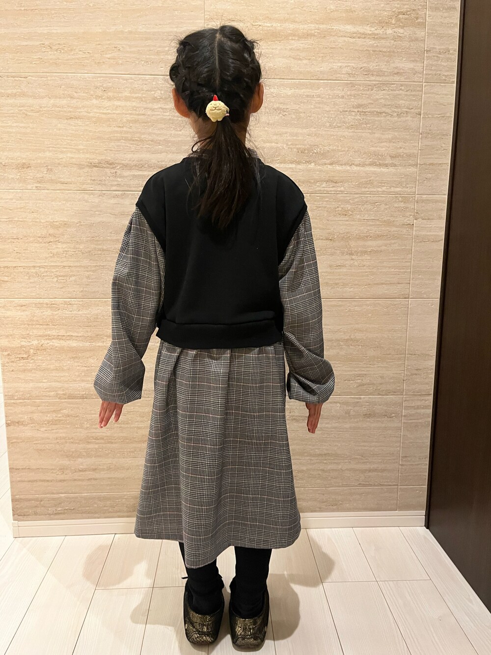 ブラック系のワンピース、ブラック系のローファー、ブラック系のレギンス/スパッツを着用したキッズの冬コーディネートの4枚目の写真