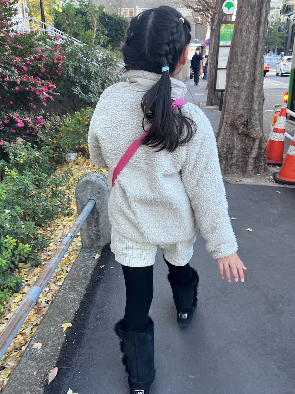 ベージュ系のノーカラージャケット、グレー系のニット/セーター、ブラック系のブーツを着用したキッズの冬コーディネートの2枚目の写真