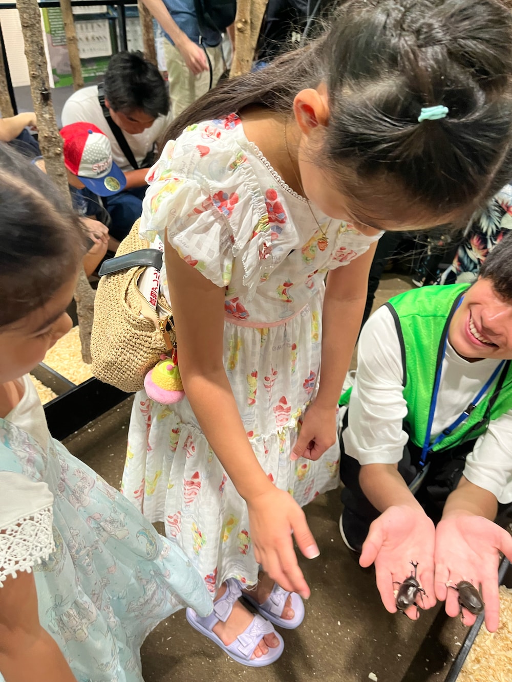 ホワイト系のワンピース、ベージュ系のかごバッグ、パープル系のサンダルを着用したキッズの夏コーディネートの3枚目の写真