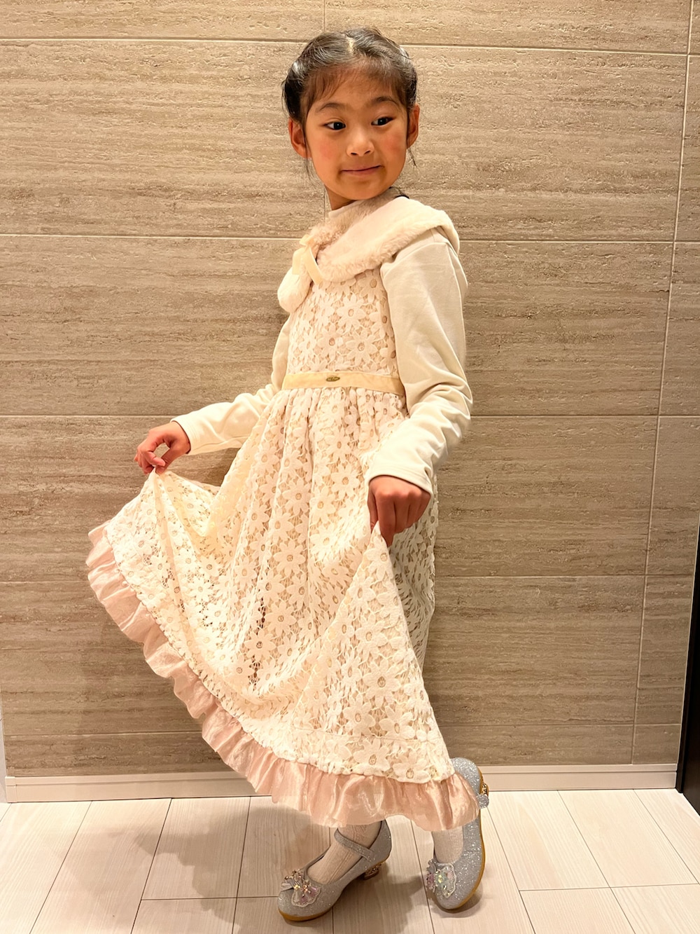 ホワイト系のドレス、シルバー系のパンプス、ホワイト系のTシャツ/カットソーを着用したキッズの冬コーディネートの2枚目の写真