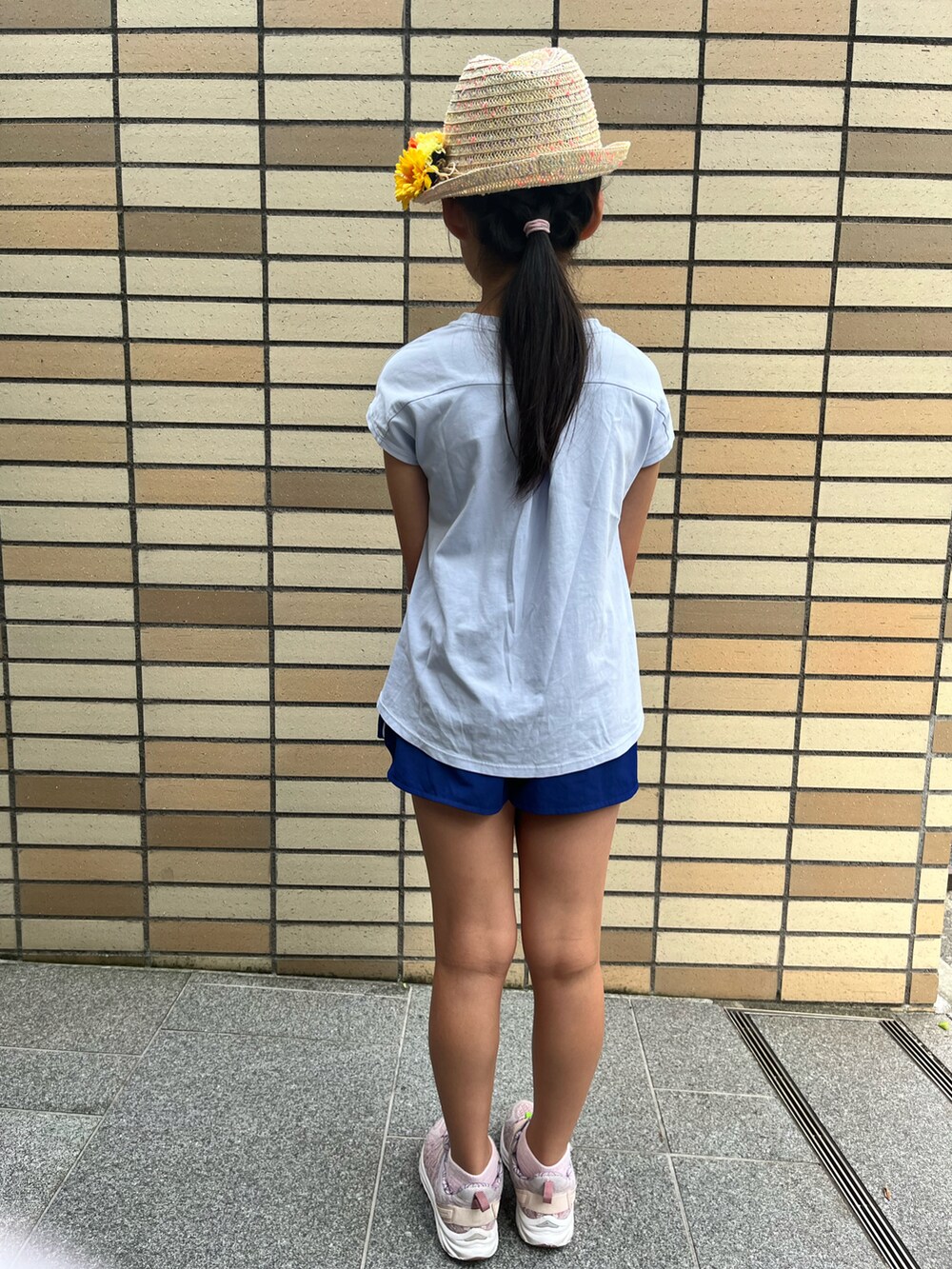 ホワイト系のTシャツ/カットソー、ピンク系のスニーカー、ベージュ系のハットを着用したキッズの夏コーディネートの3枚目の写真