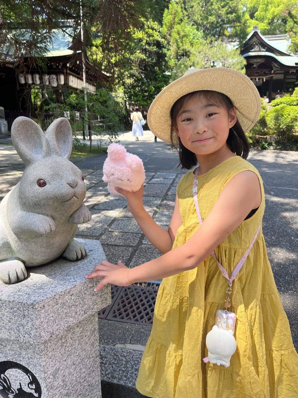 イエロー系のワンピース、パープル系のサンダル、ベージュ系のハットを着用したキッズの春コーディネートの2枚目の写真