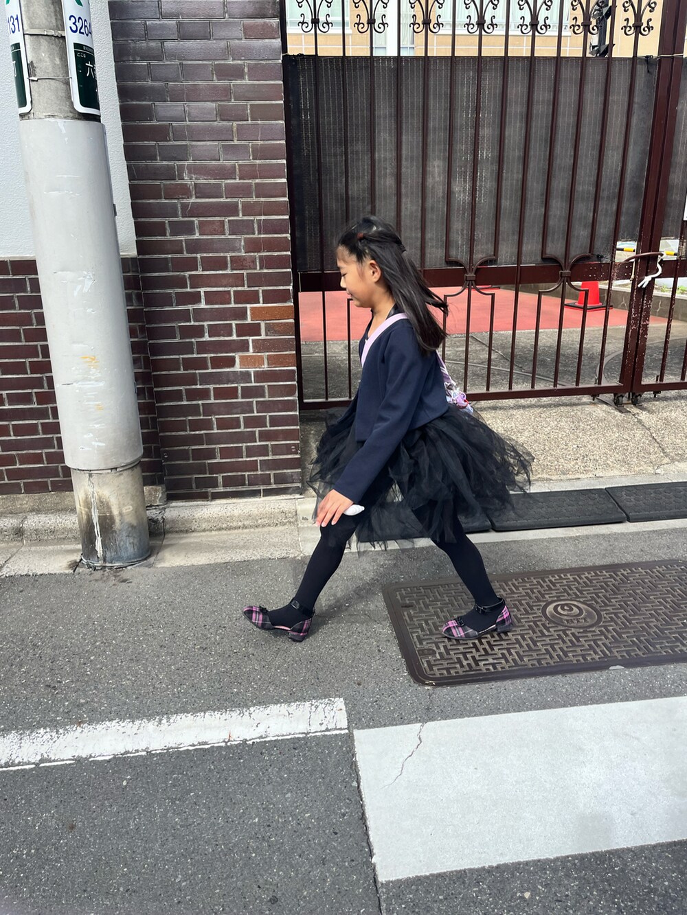 ブラック系のワンピース、パープル系のパンプスを着用したキッズの秋コーディネートの2枚目の写真