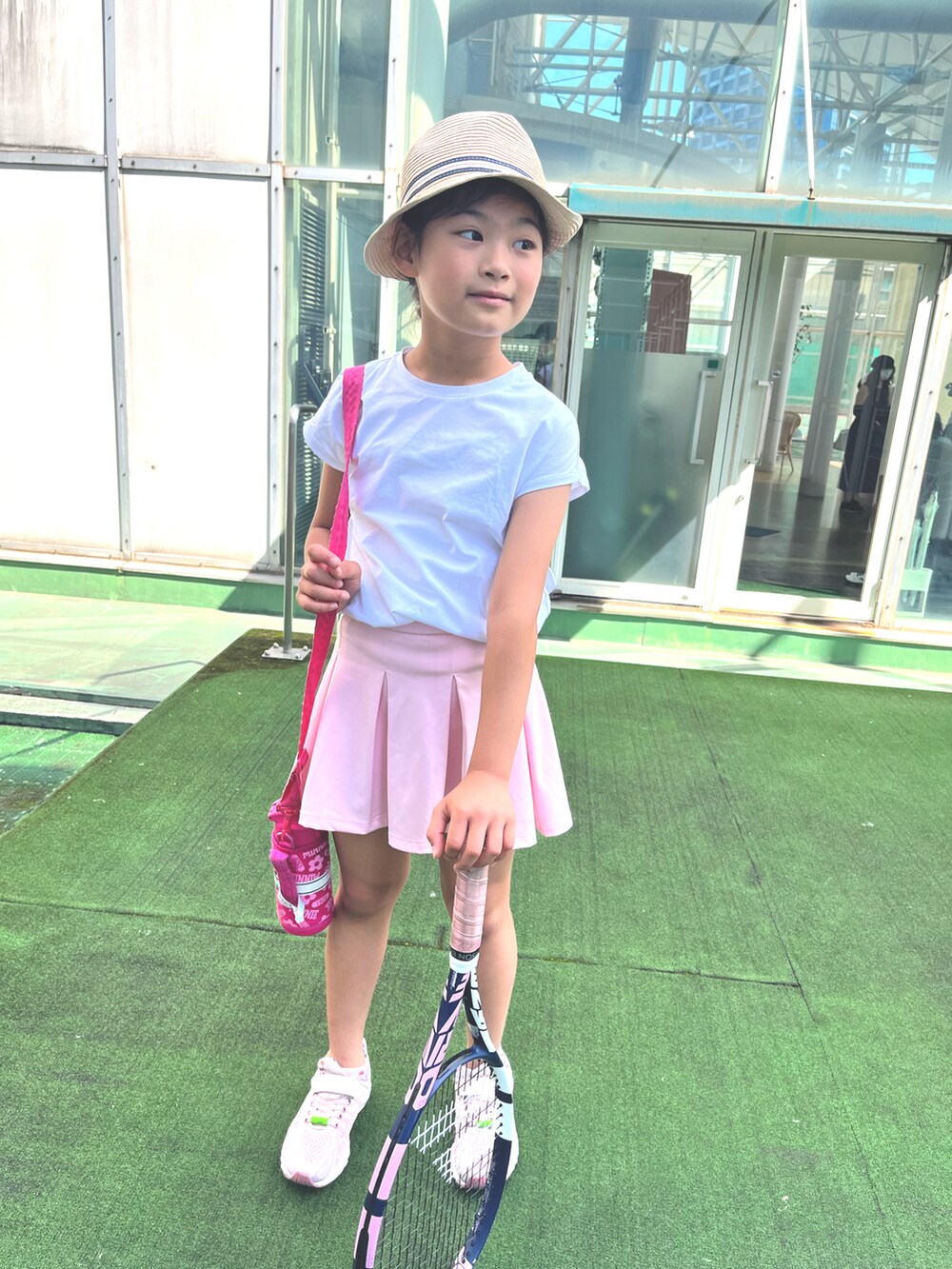 ホワイト系のTシャツ/カットソー、ピンク系のスニーカー、ベージュ系のハットを着用したキッズの夏コーディネートの2枚目の写真