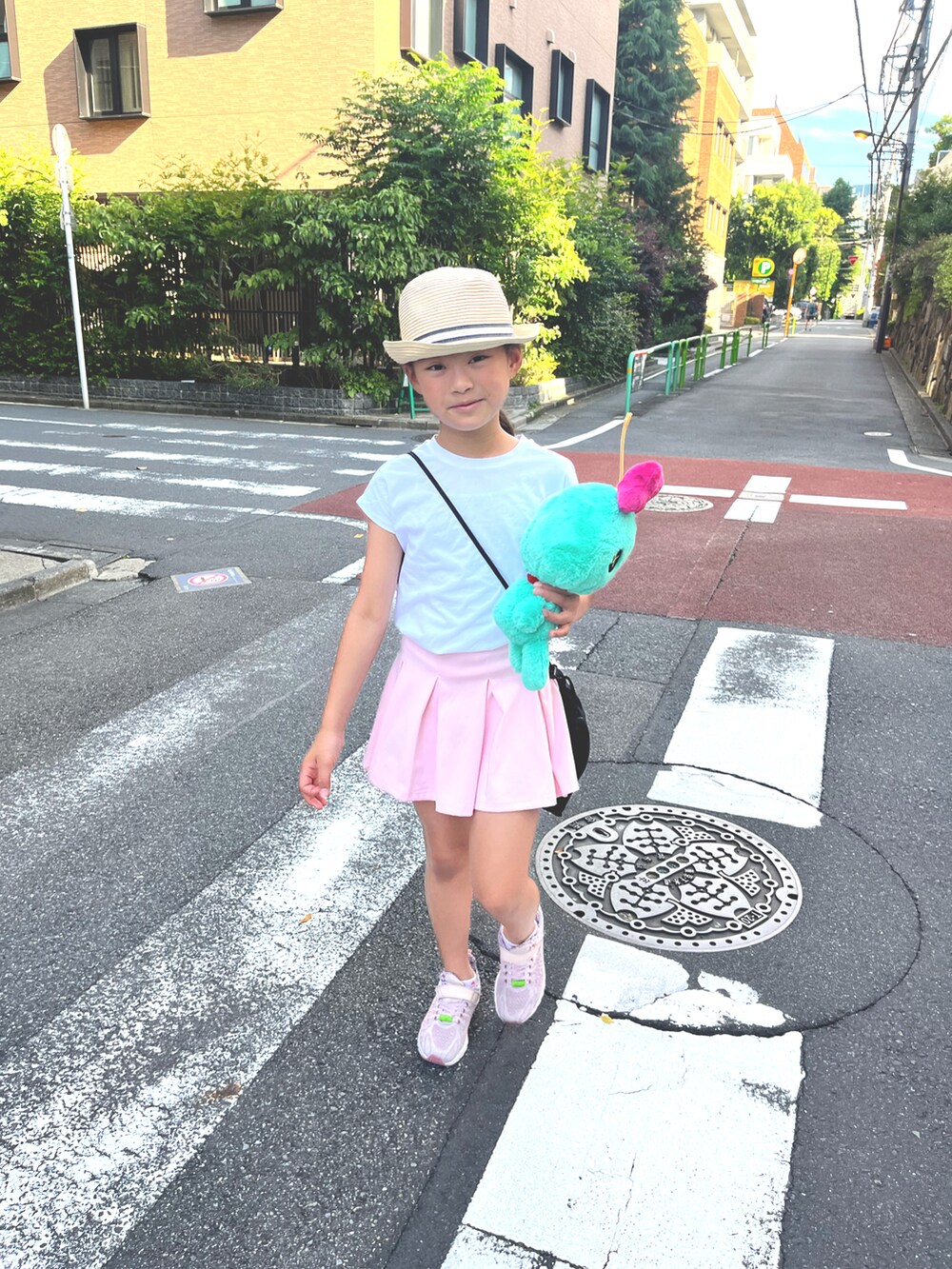 ホワイト系のTシャツ/カットソー、ピンク系のスニーカー、ベージュ系のハットを着用したキッズの夏コーディネートの4枚目の写真