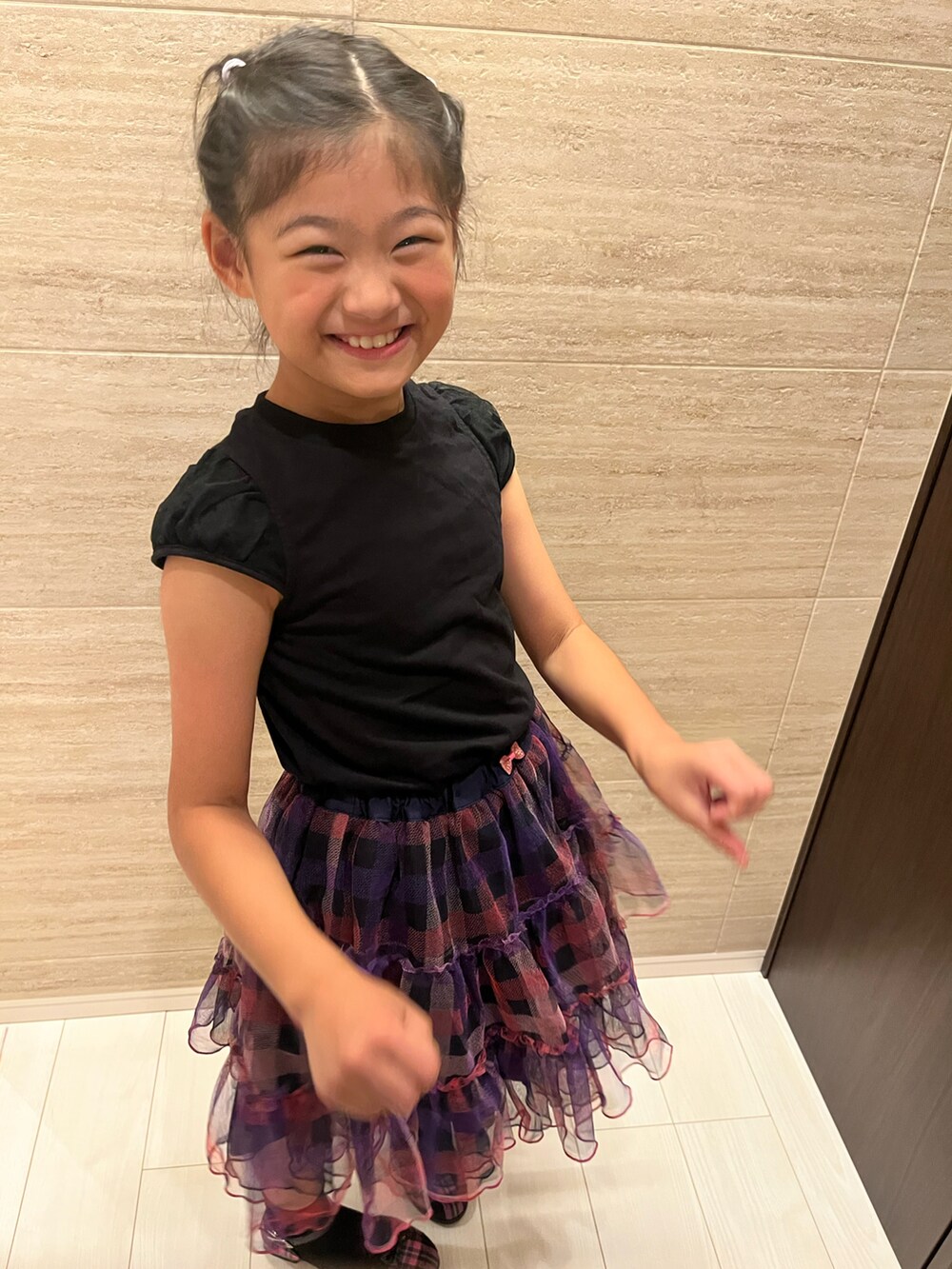 ブラック系のTシャツ/カットソー、パープル系のスカート、パープル系のパンプスを着用したキッズの秋コーディネートの4枚目の写真