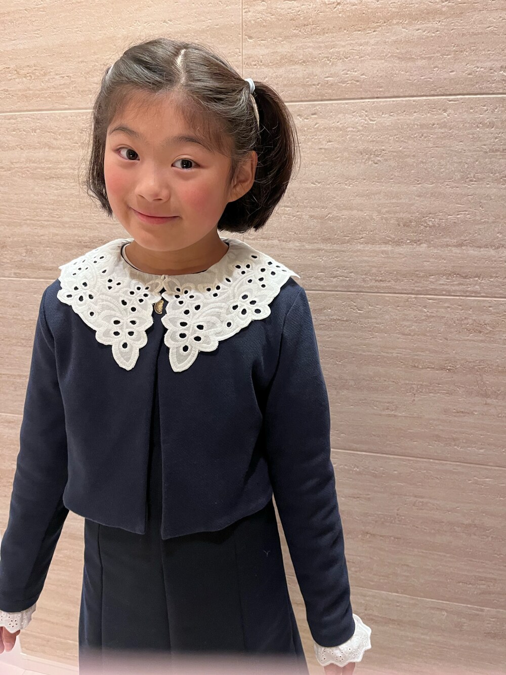 ブラック系のワンピース、ブラック系のノーカラージャケット、ブラック系のローファーを着用したキッズの冬コーディネートの3枚目の写真