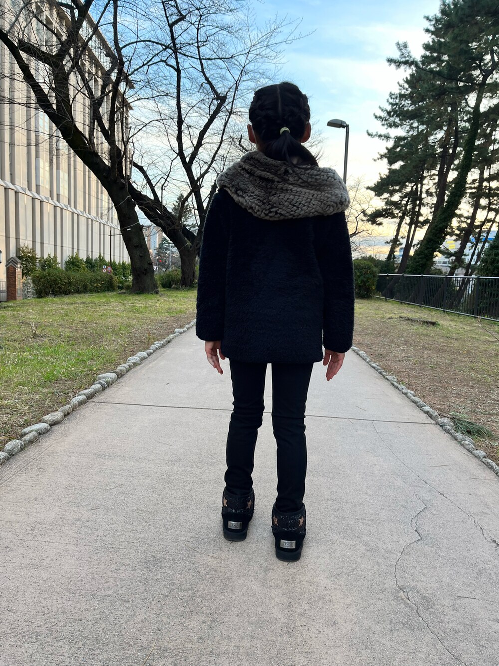 ブラック系のノーカラージャケット、ブルー系のデニムパンツ、ブラック系のローファーを着用したキッズの冬コーディネートの2枚目の写真