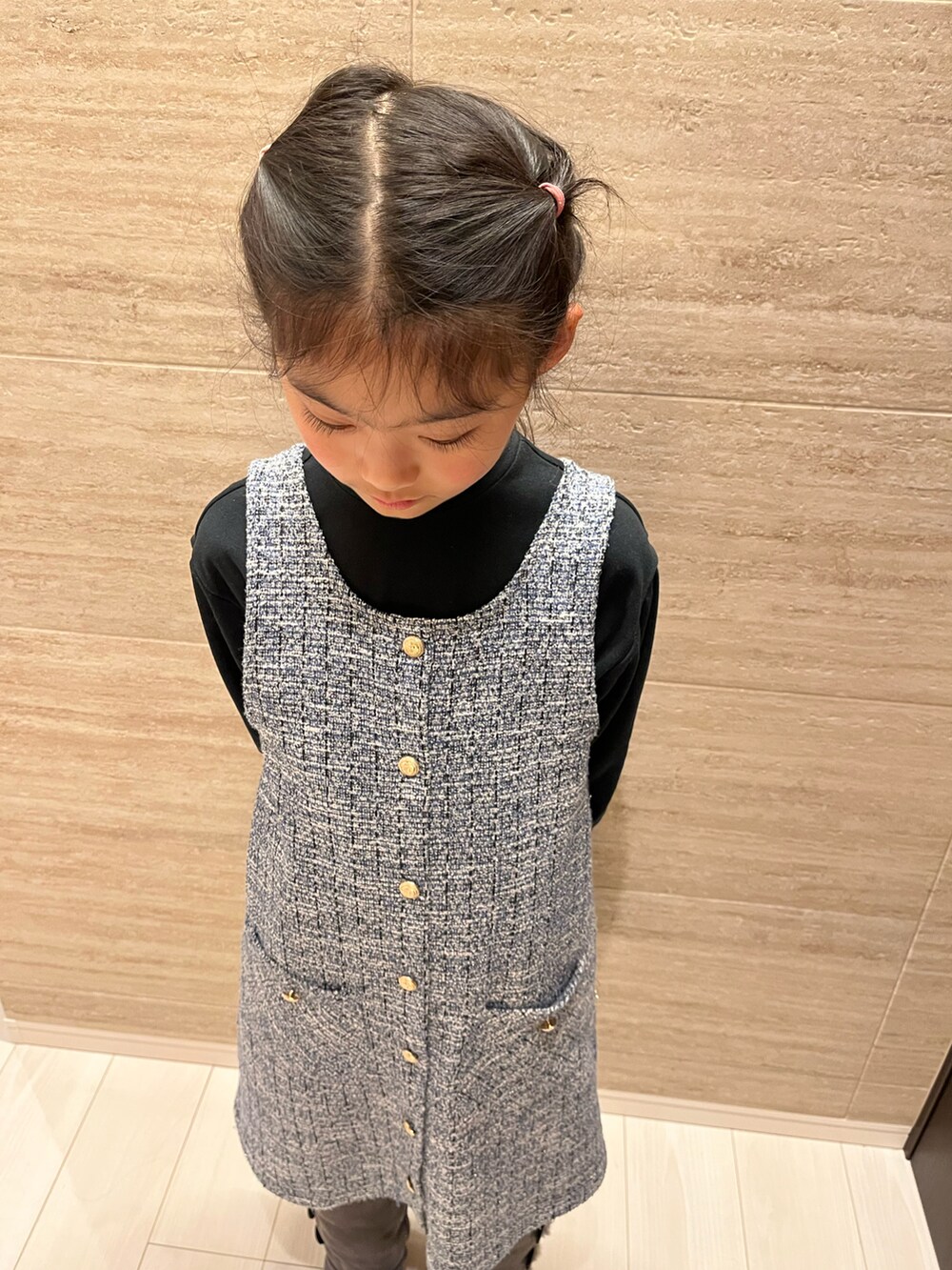 ブラック系のTシャツ/カットソー、ブルー系のジャンパースカート、グレー系のブーツを着用したキッズの冬コーディネートの3枚目の写真