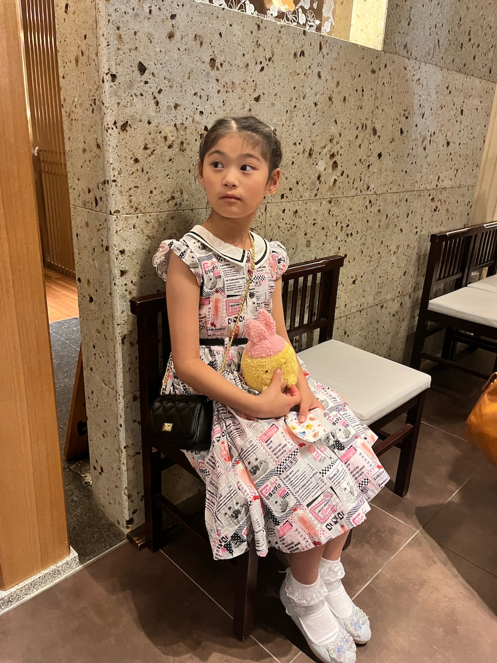 ホワイト系のカーディガン/ボレロ、ホワイト系のワンピース、シルバー系のパンプスを着用したキッズの春コーディネートの2枚目の写真