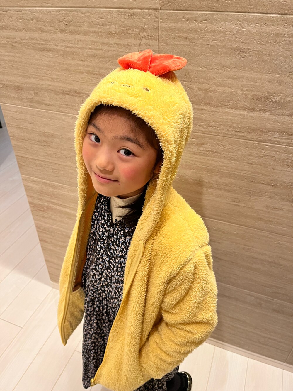 イエロー系のジャケット/アウター、ホワイト系のTシャツ/カットソー、ブルー系のワンピースを着用したキッズの冬コーディネートの3枚目の写真