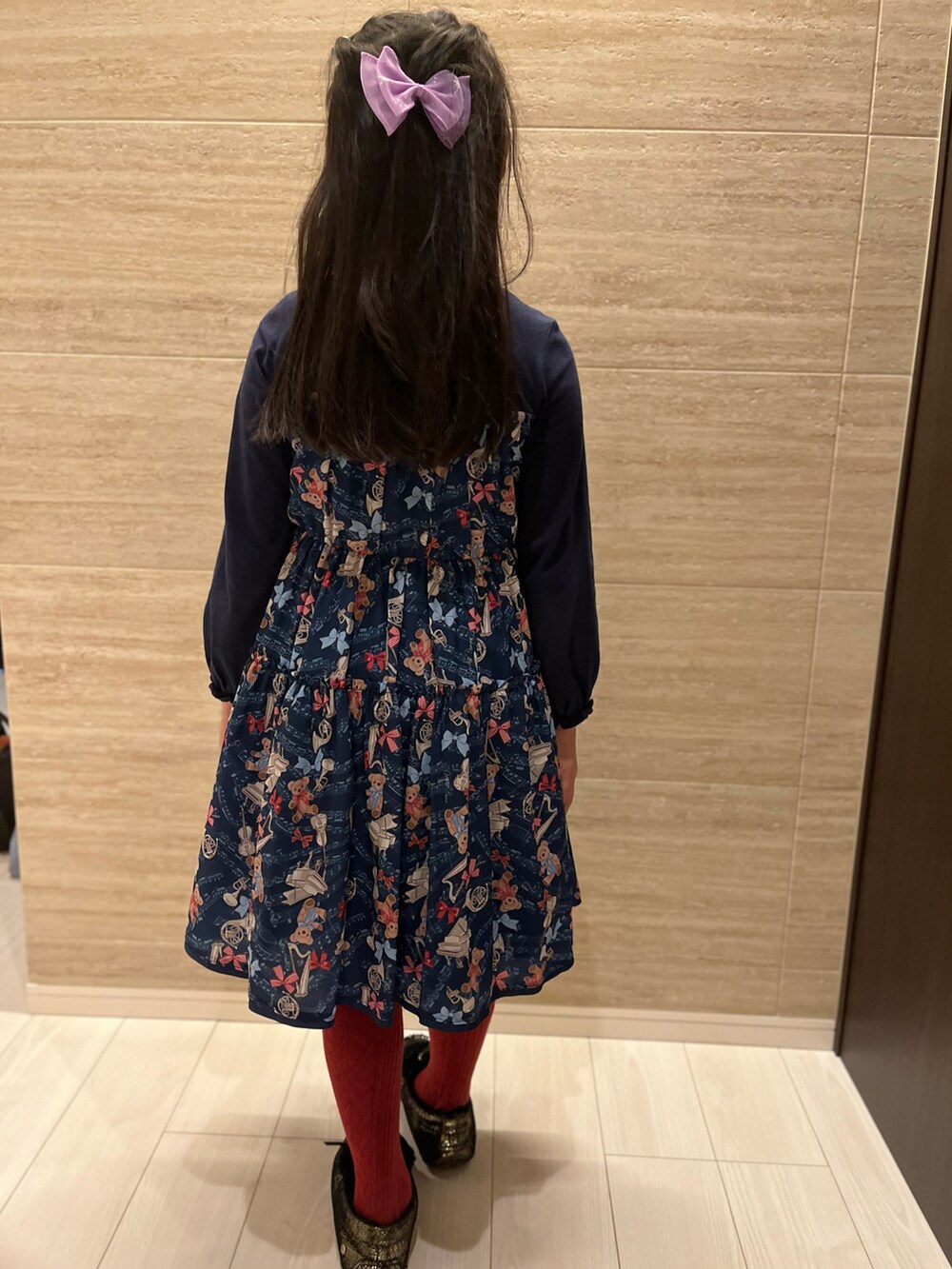 ブルー系のワンピース、ブラック系のモカシン/デッキシューズ、レッド系のソックス/靴下を着用したキッズの秋コーディネートの3枚目の写真