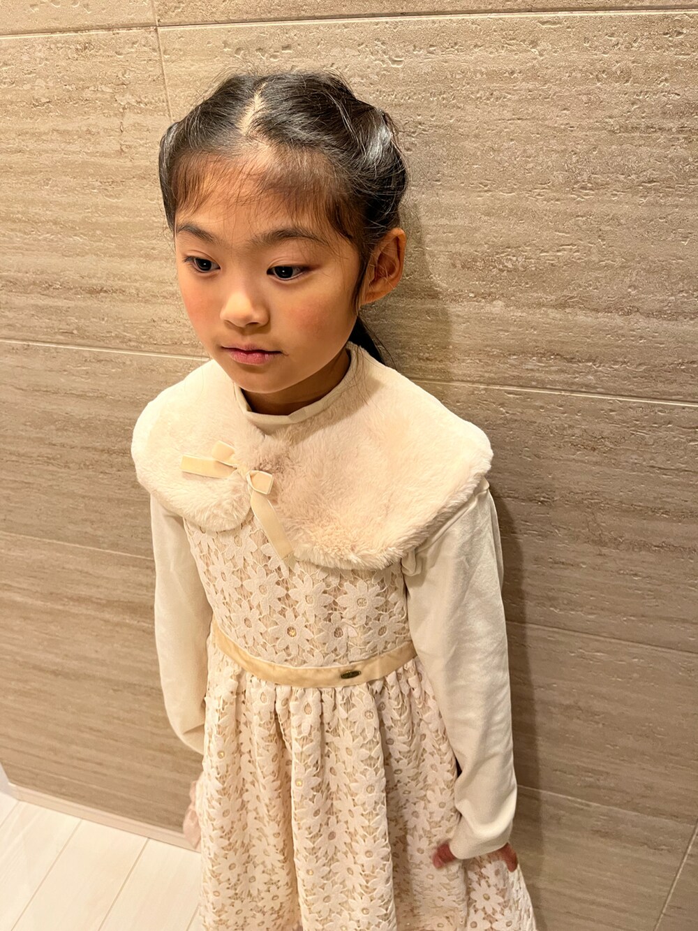 ホワイト系のドレス、シルバー系のパンプス、ホワイト系のTシャツ/カットソーを着用したキッズの冬コーディネートの3枚目の写真