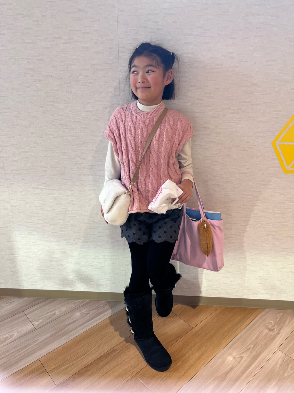 ピンク系のベスト、グレー系のその他パンツ、ブラック系のブーツを着用したキッズの冬コーディネートの2枚目の写真