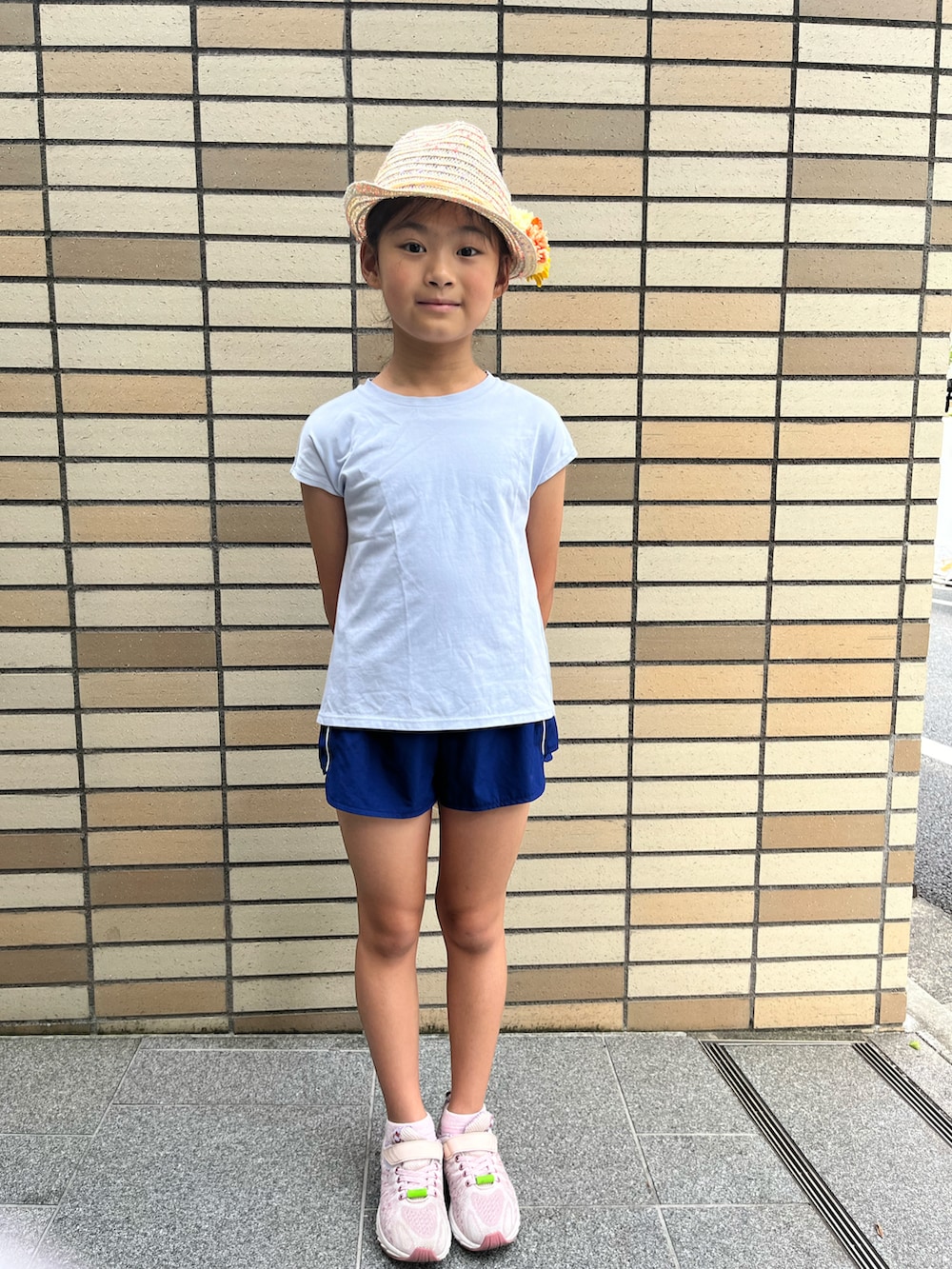 ホワイト系のTシャツ/カットソー、ピンク系のスニーカー、ベージュ系のハットを着用したキッズの夏コーディネートの2枚目の写真